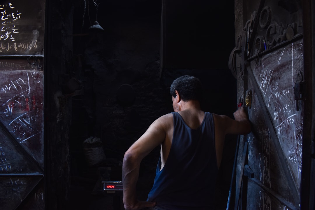 A man opens a dark door., iron worker