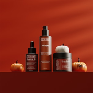 Skincare products displayed with pumpkins for autumn.