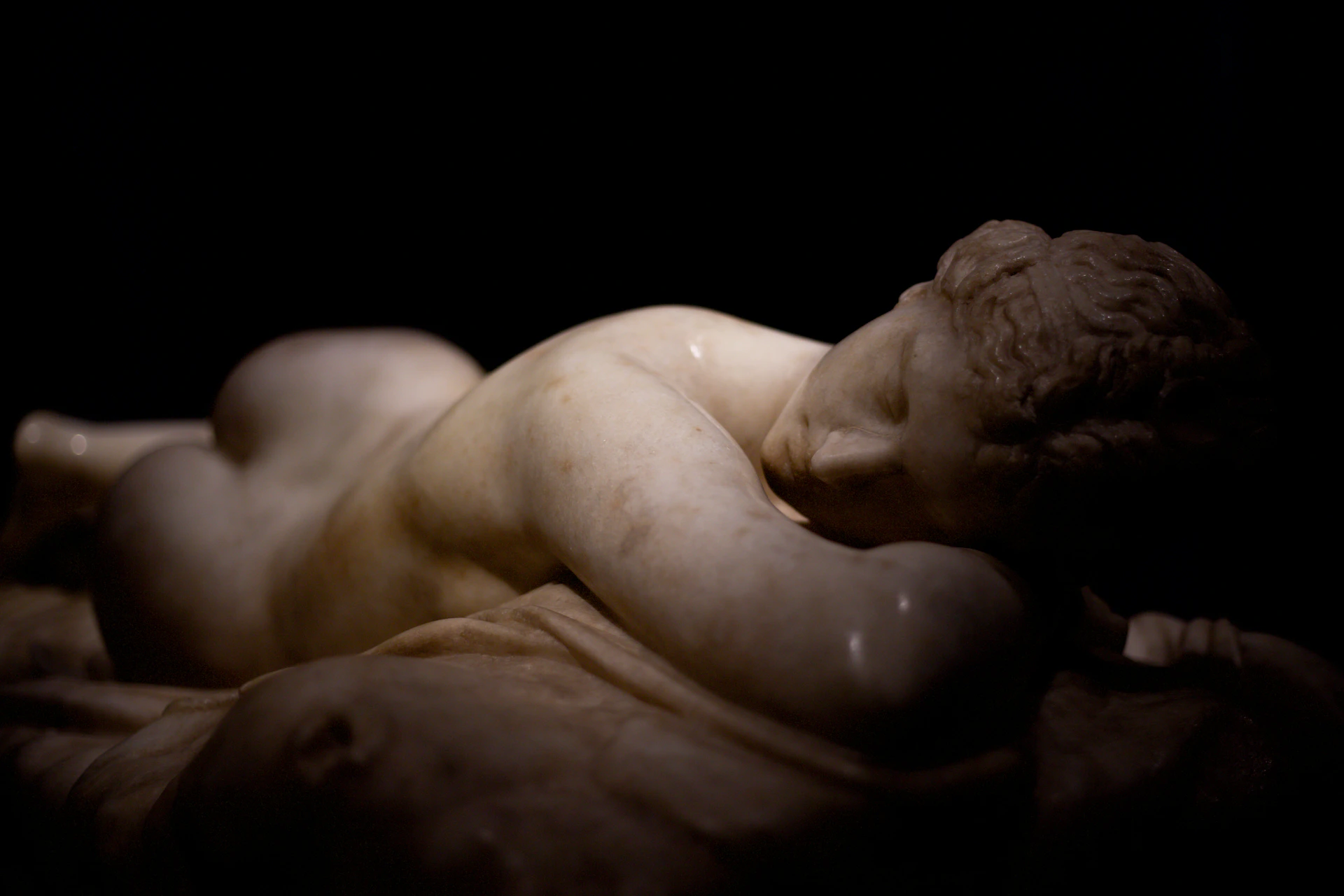 A marble sculpture of a reclining woman.