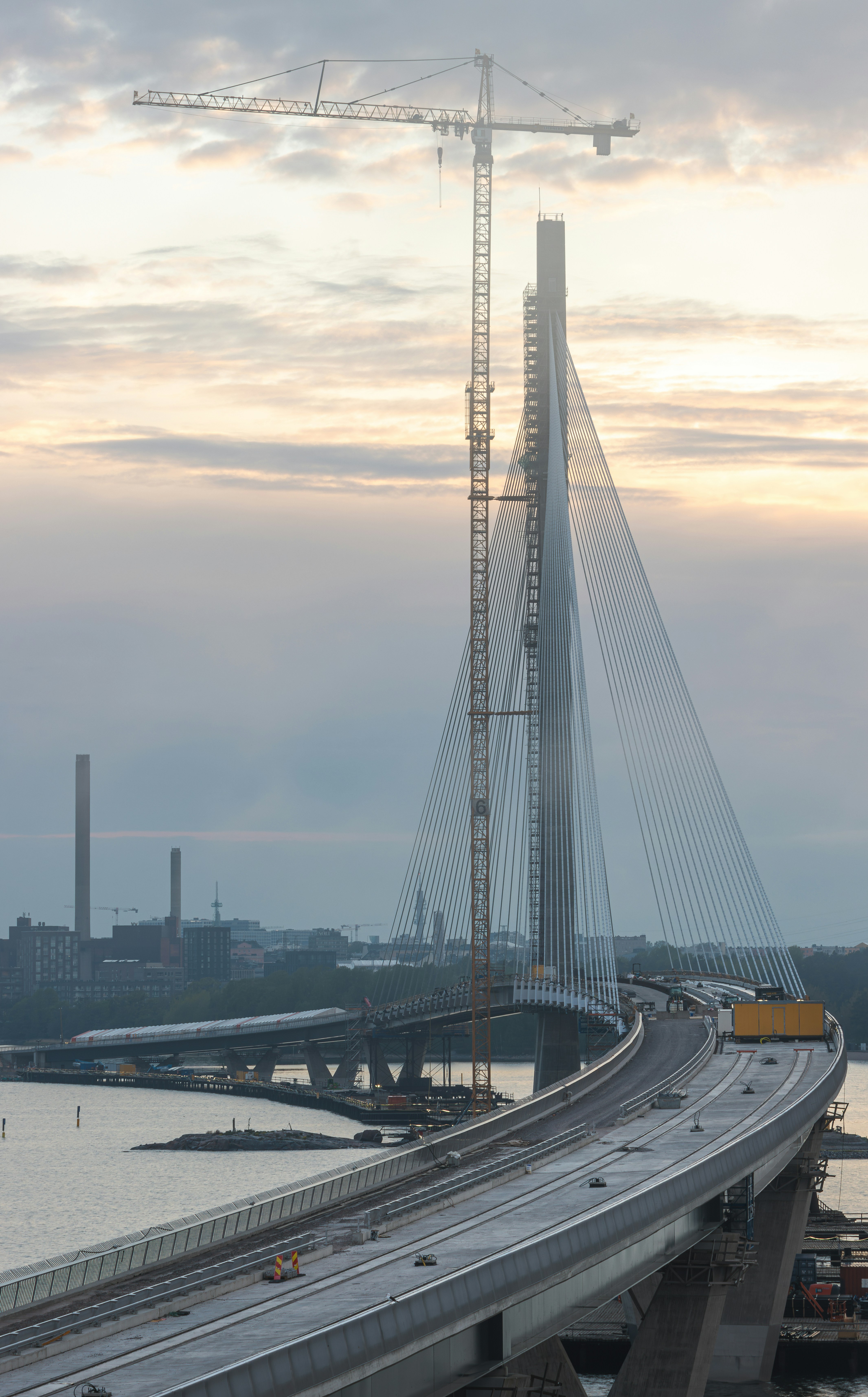 Brückenbau vor einem dämmrigen, bewölkten Himmel.