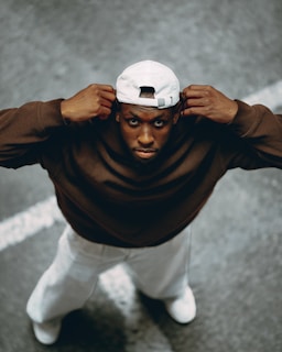 A man poses while holding his white cap.