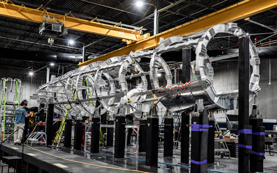 A large aircraft fuselage under construction.