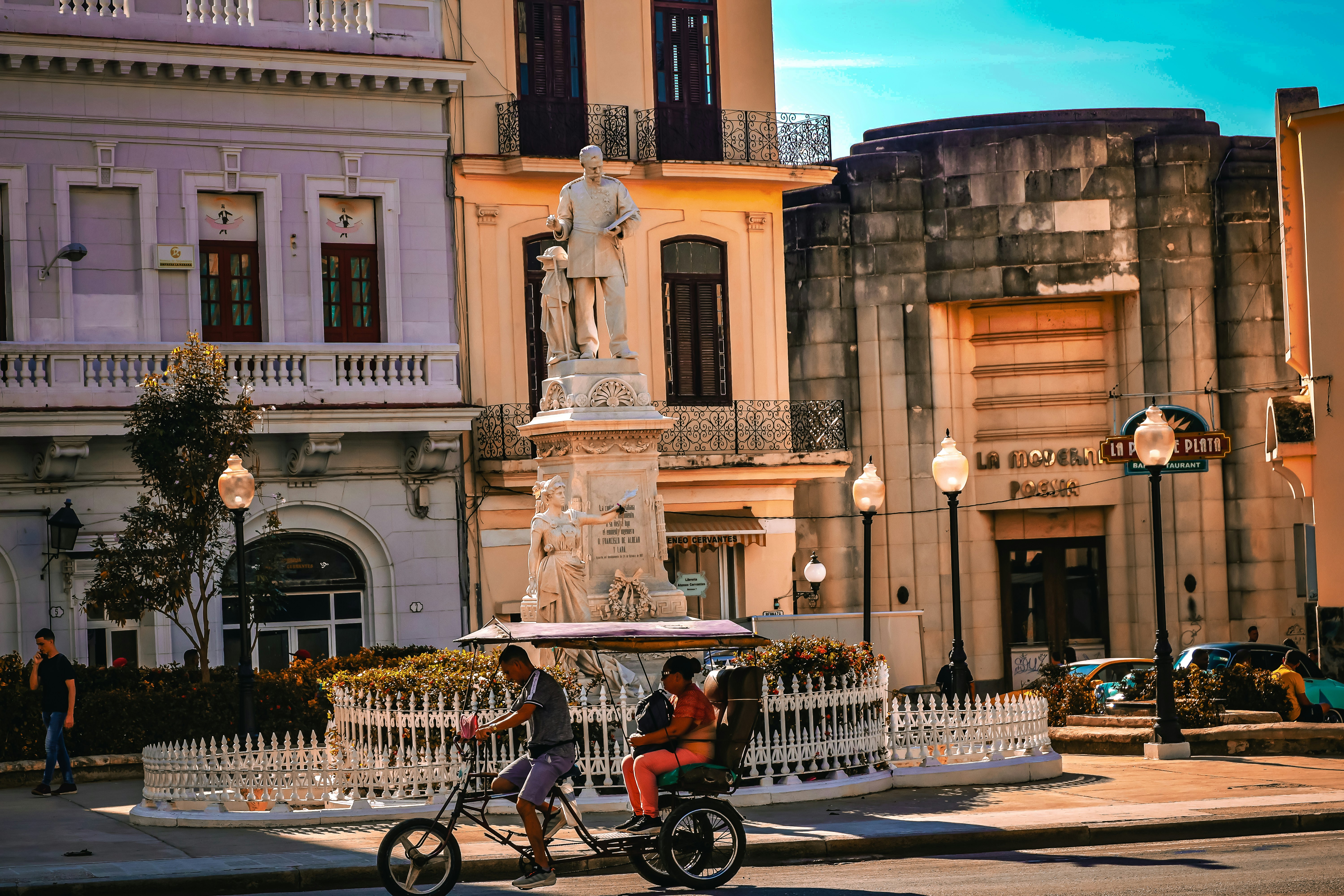 Colorful buildings and a statue in a city square.
