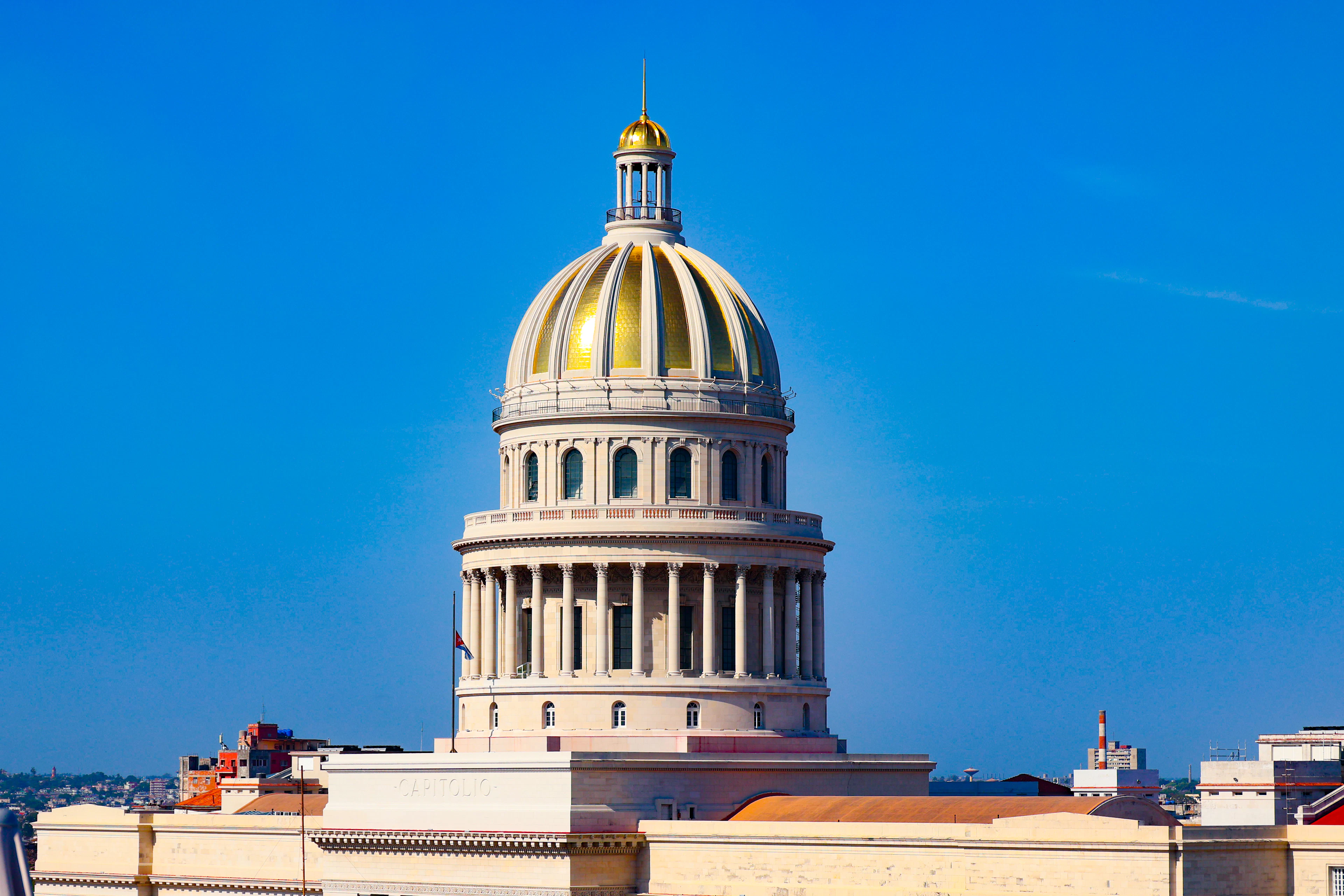 The white and gold dome of El Capitolio rising above Havana's rooftops against a clear blue sky