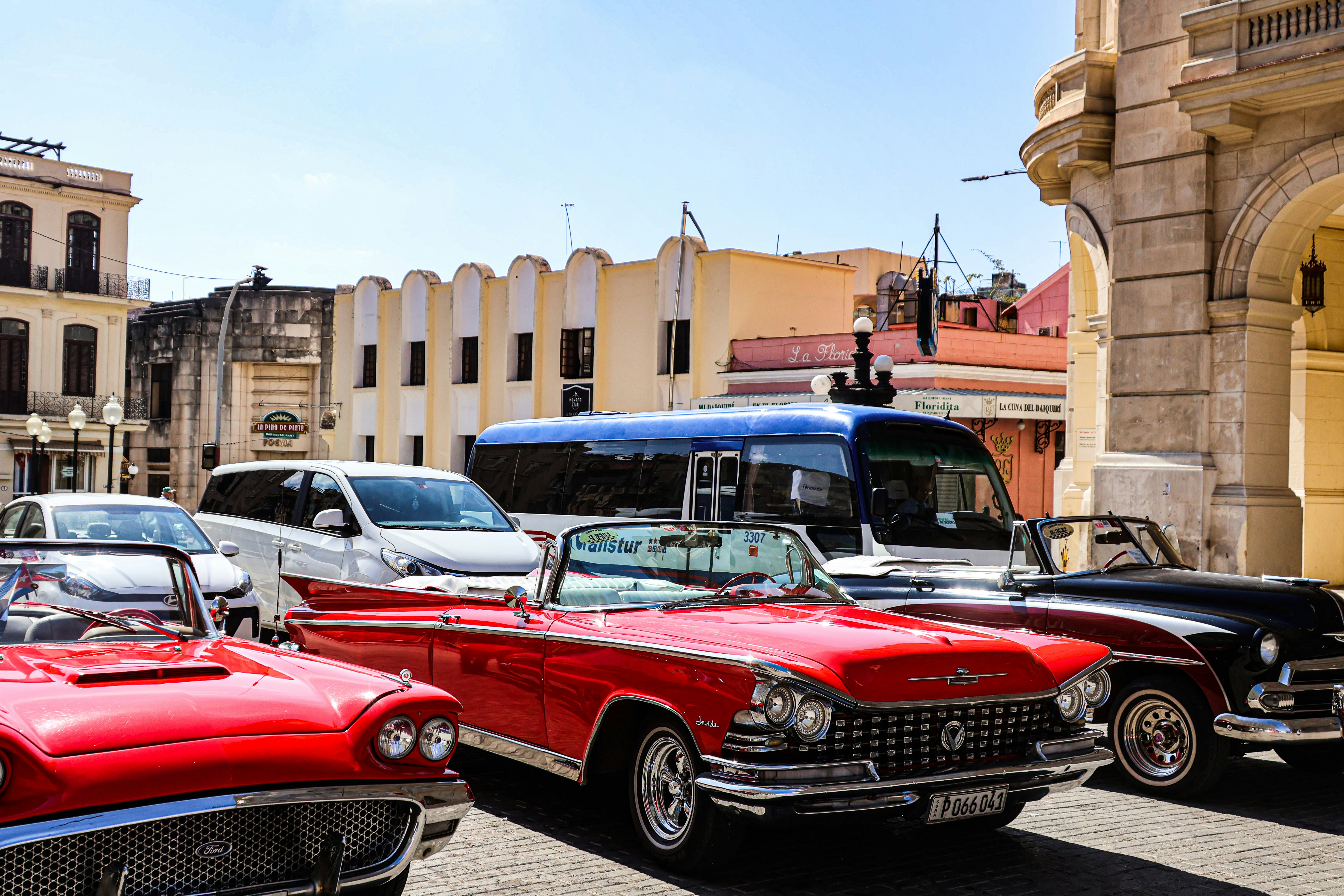 Classic cars parked on a vibrant city street.