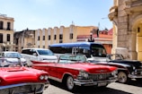 Classic cars parked on a vibrant city street.