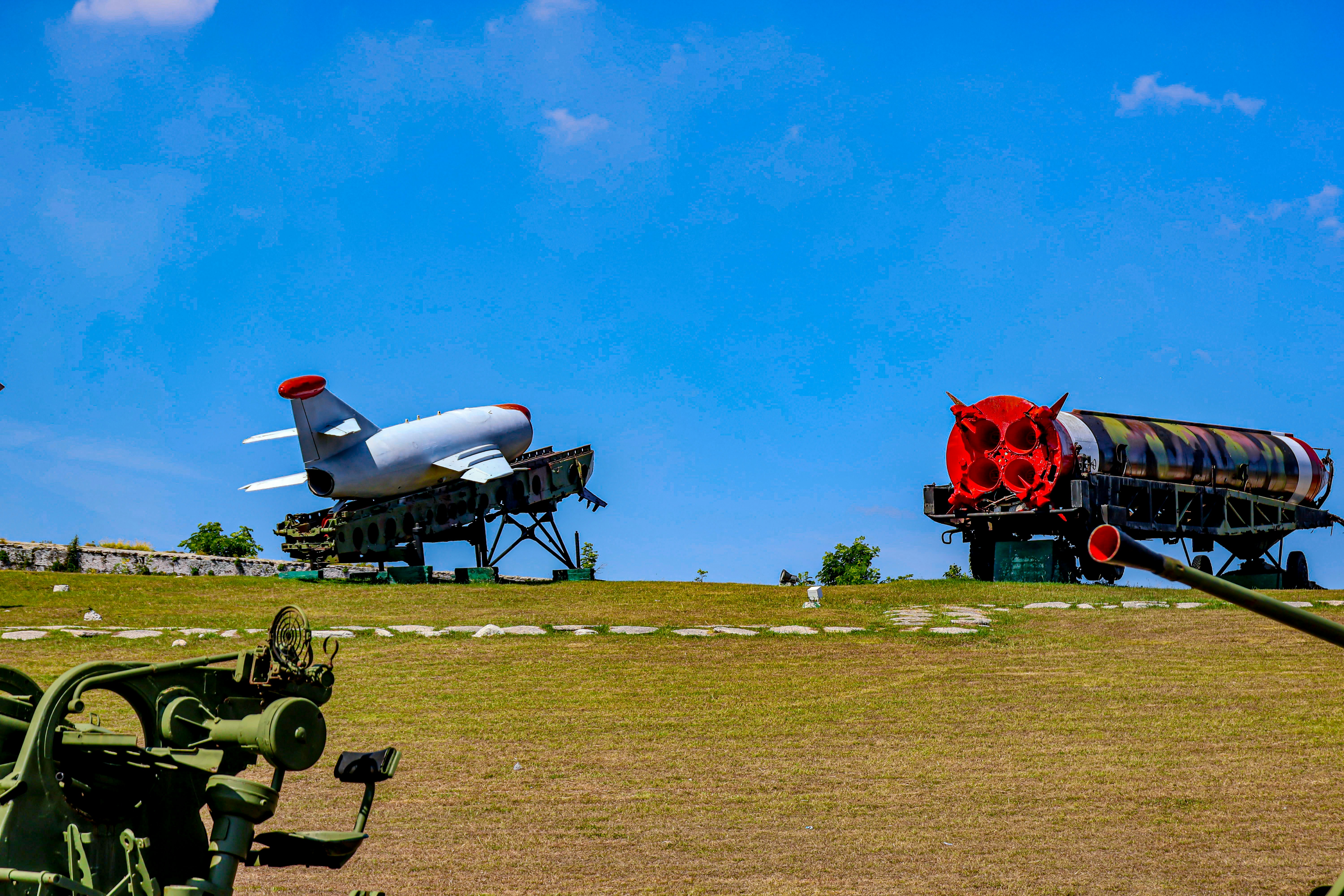 Military aircraft are on display under a blue sky.
