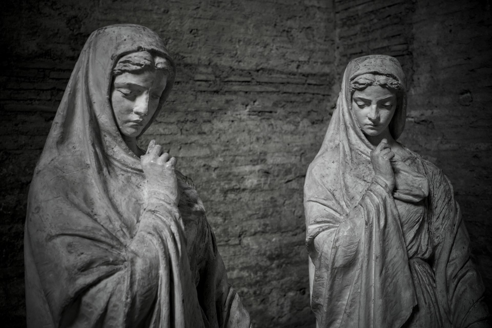 Two veiled statues in somber black and white.