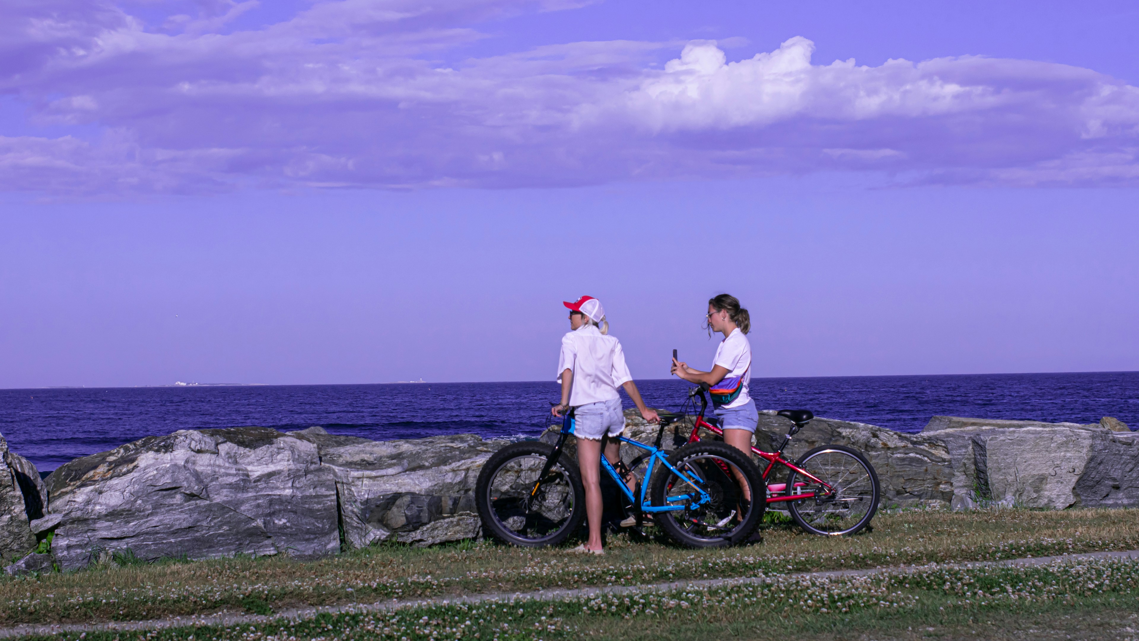 Two friends with bikes enjoy the ocean view.