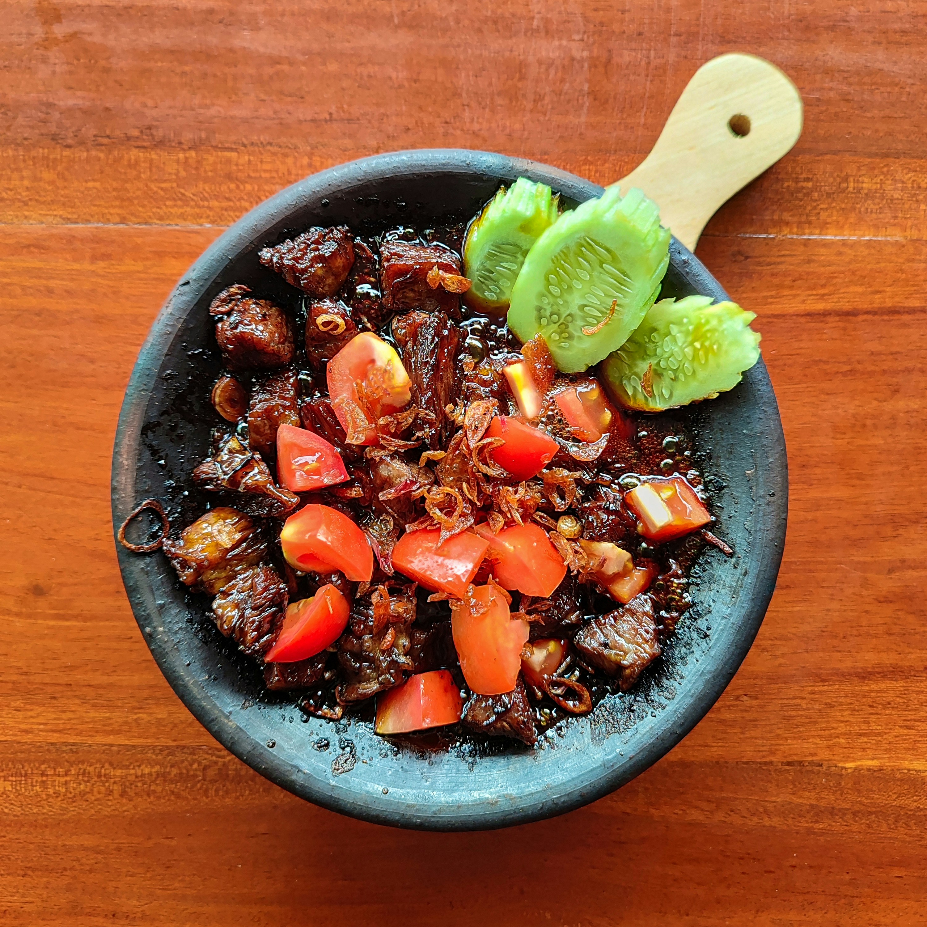 Makanan indonesia yang lezat disajikan dalam piring hitam.