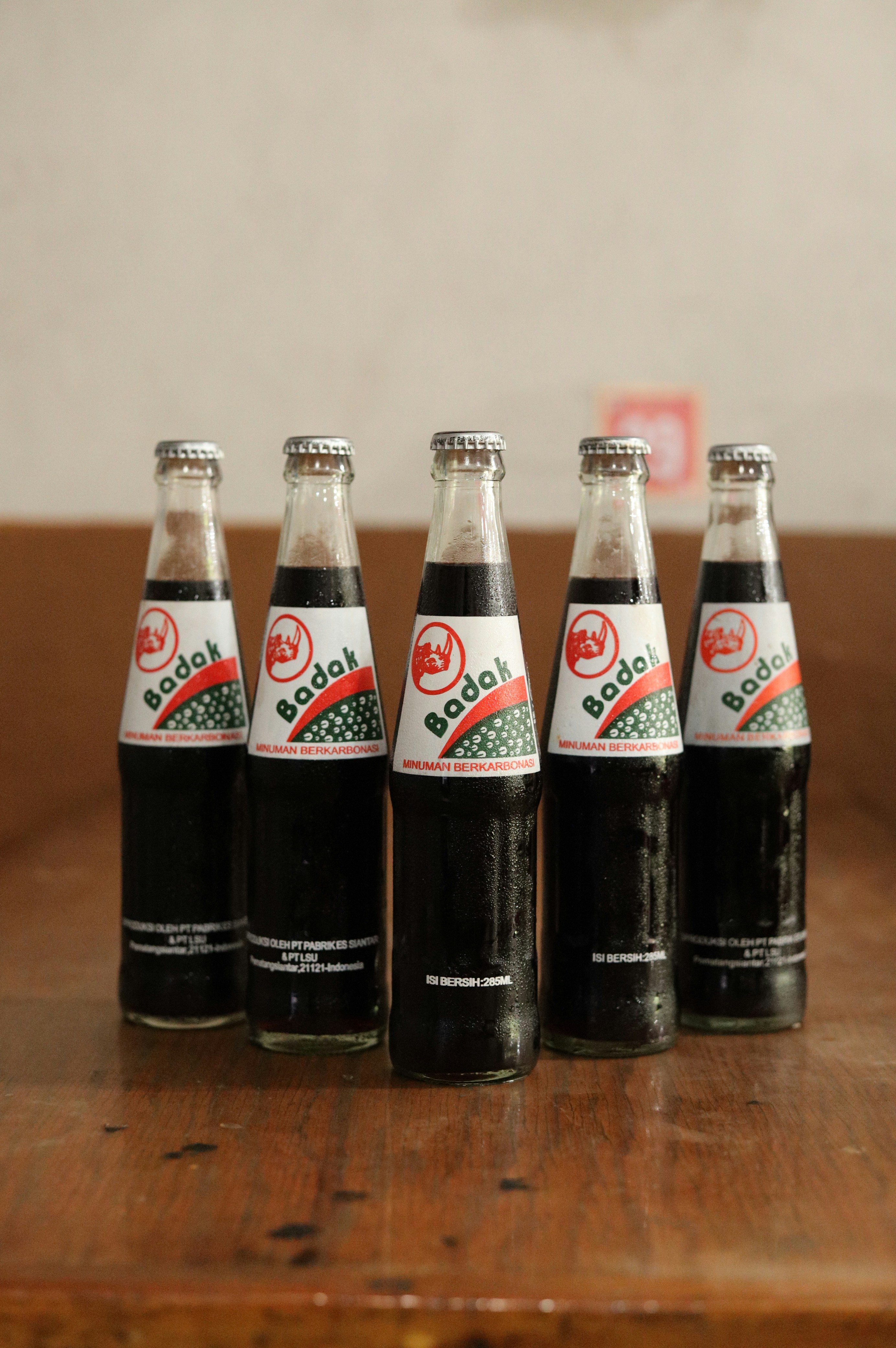 Lima botol soda "badak" berdiri di atas meja