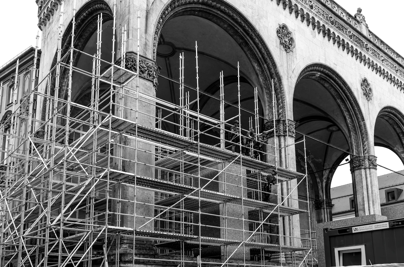 Historic stone facade undergoing repair behind scaffolding