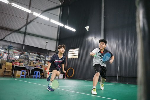 ダブルスでシャトルを追う2人の子ども