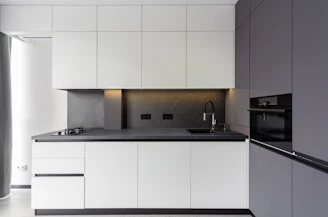 A modern kitchen features sleek white and gray cabinets