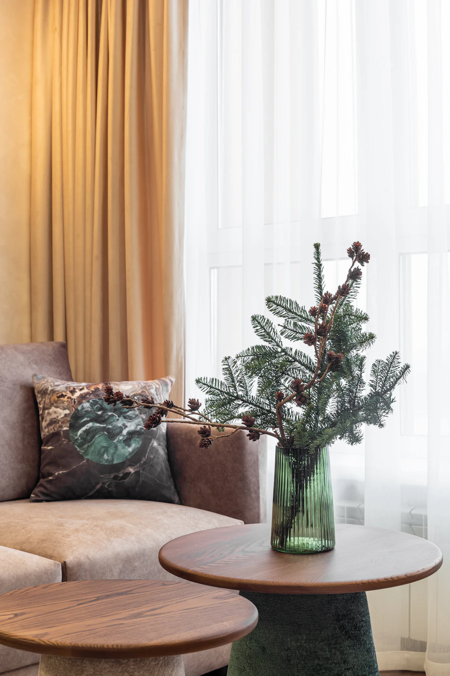 A small Christmas tree beside a cozy sofa