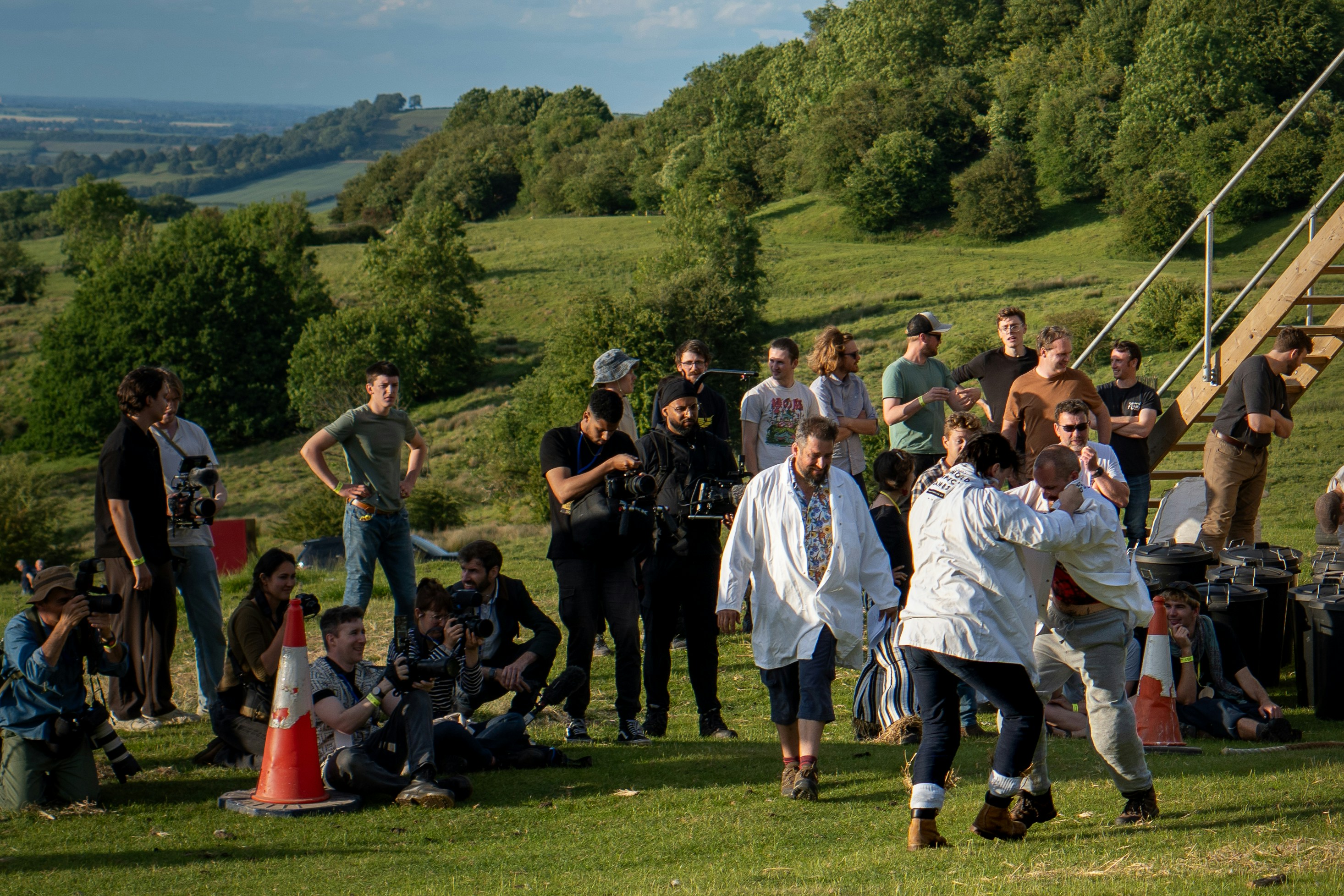 Filmer une scène sur une colline herbeuse avec beaucoup de monde.