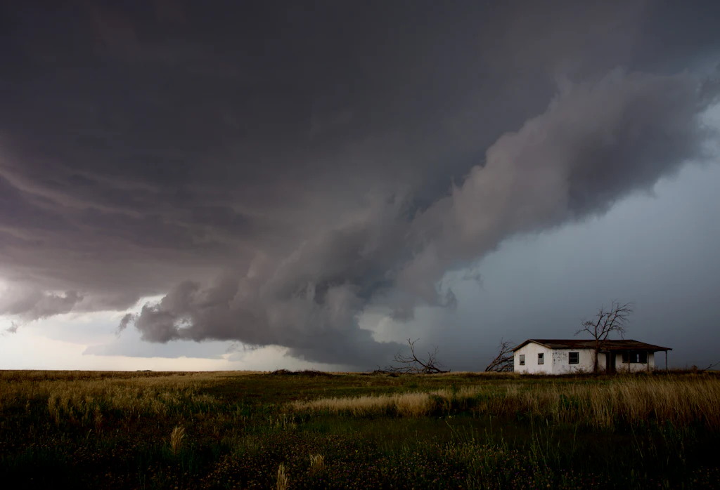 Dark storm cloud moving over a small house