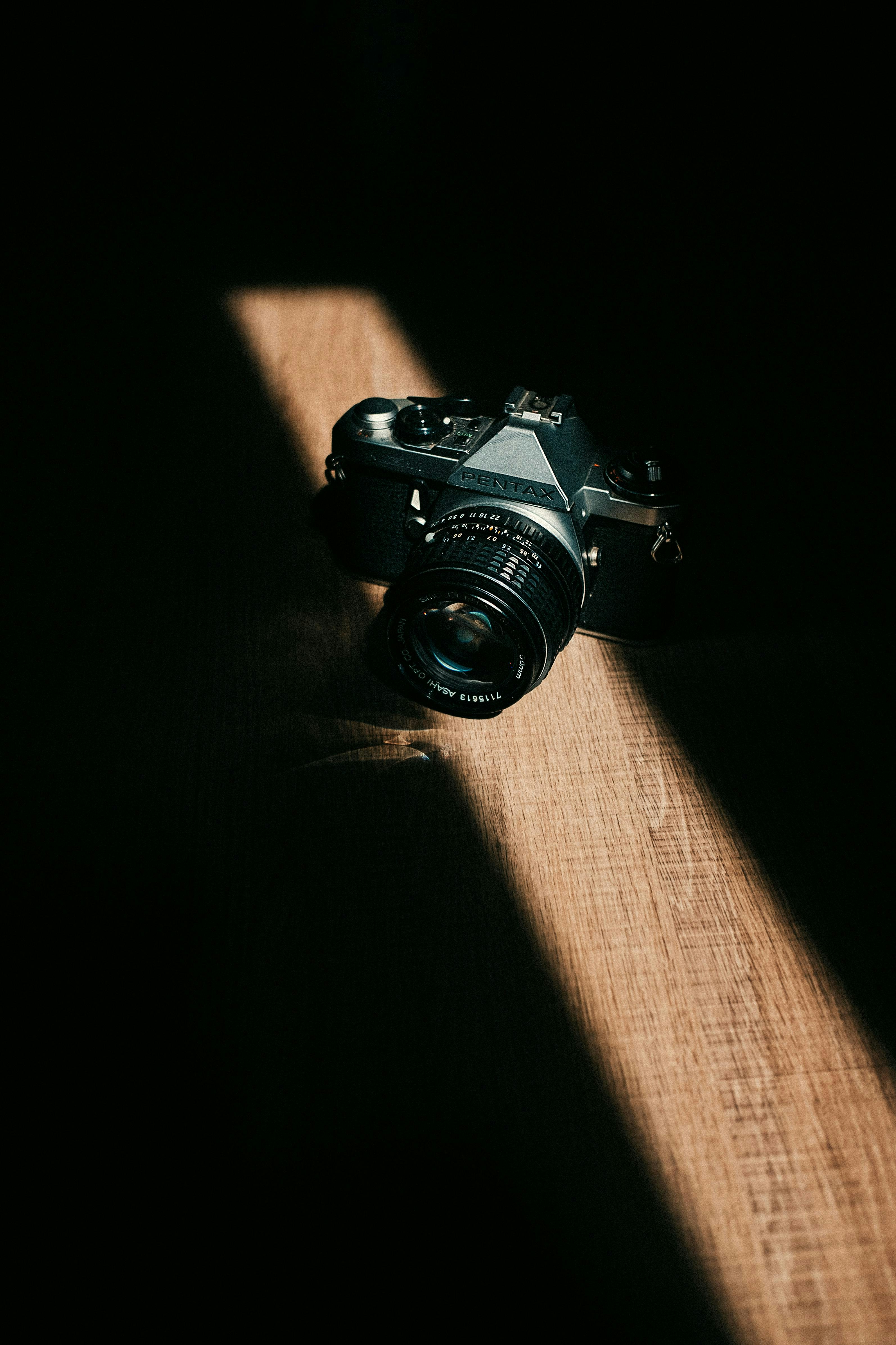 Vintage camera sits in a beam of light.