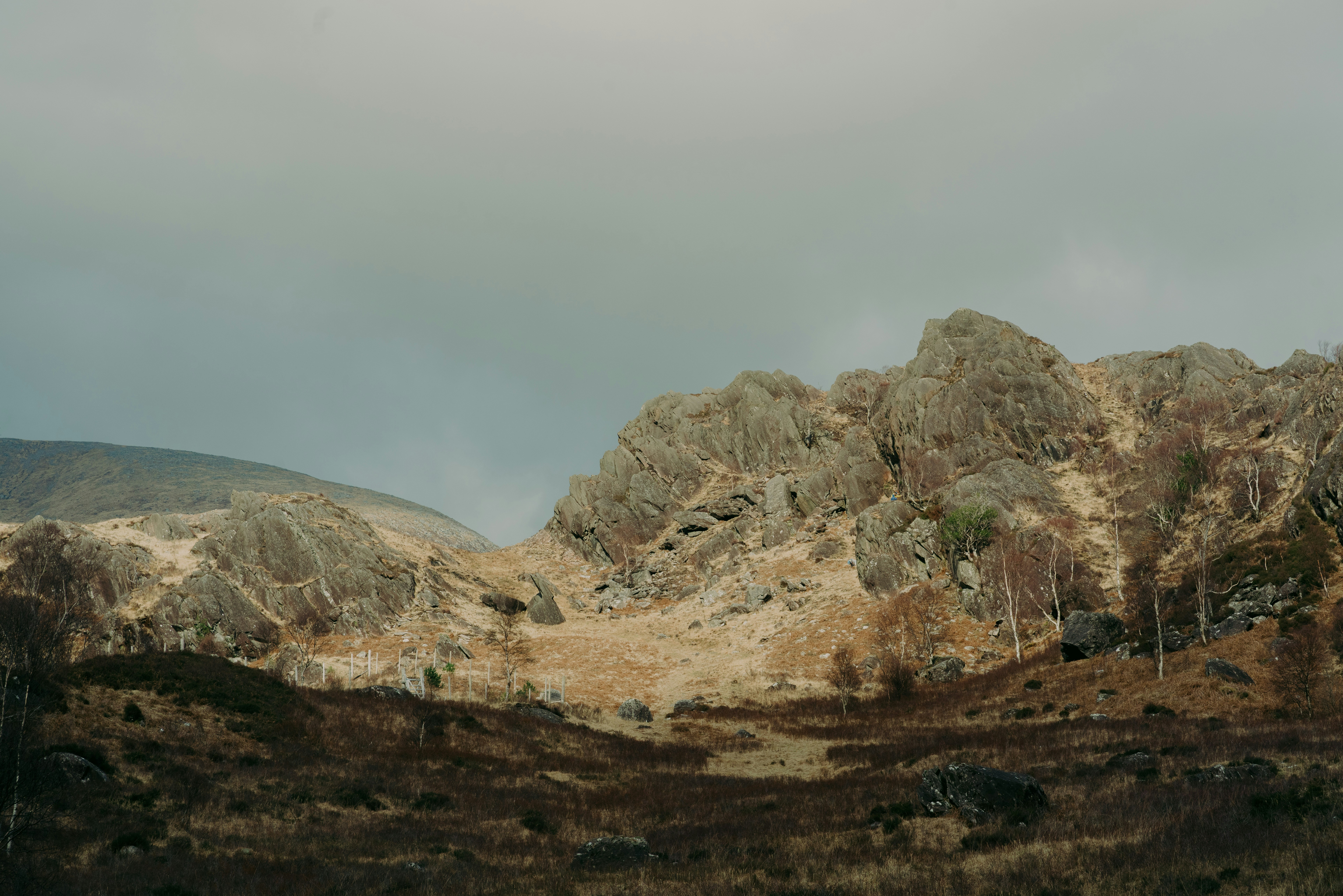 Rugged mountains stand under a cloudy sky.