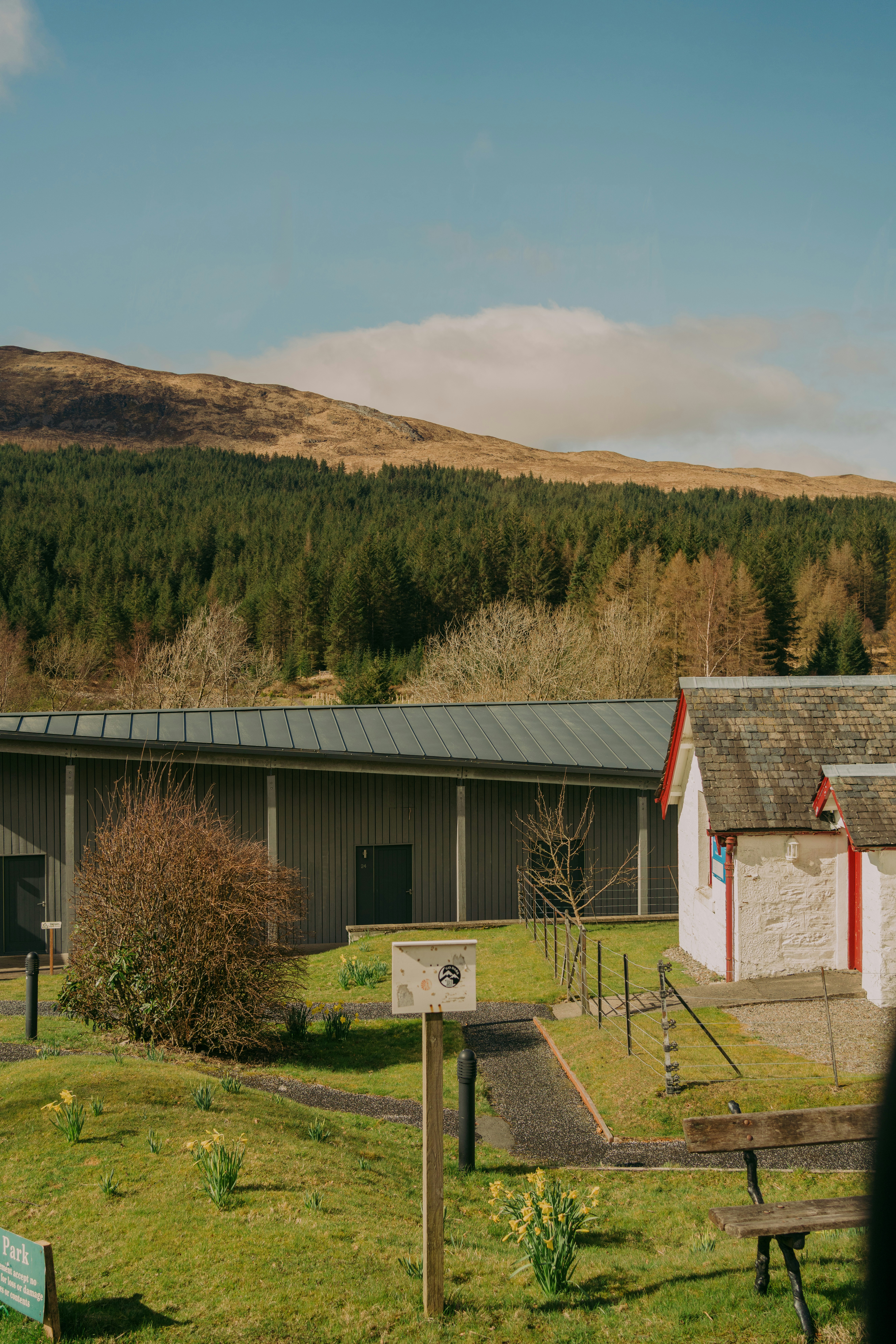 A green landscape with buildings and mountains.