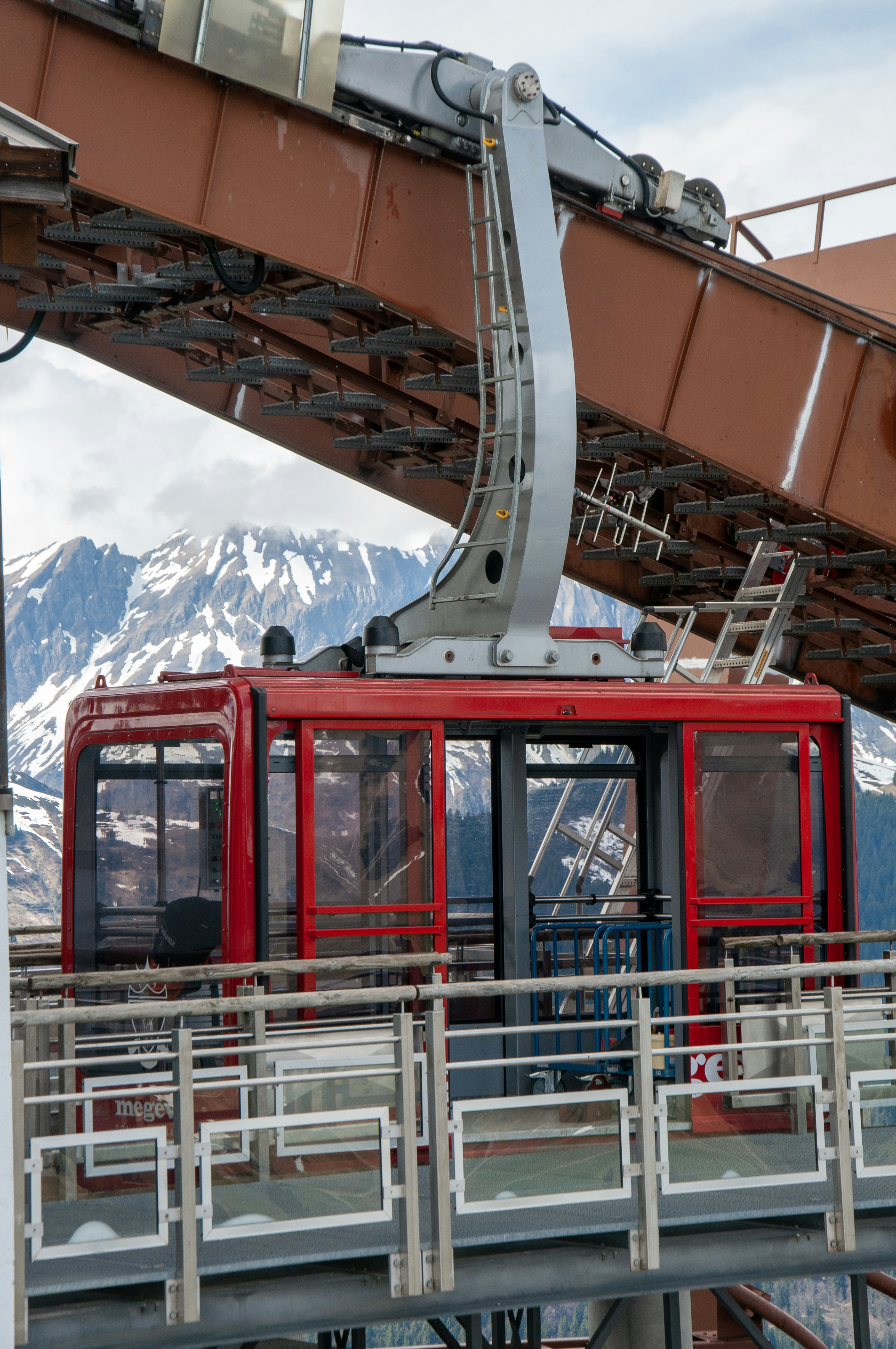 A red cable car ascends with a snowy mountain view