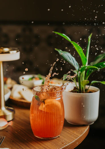 A drink is splashing out of a glass.