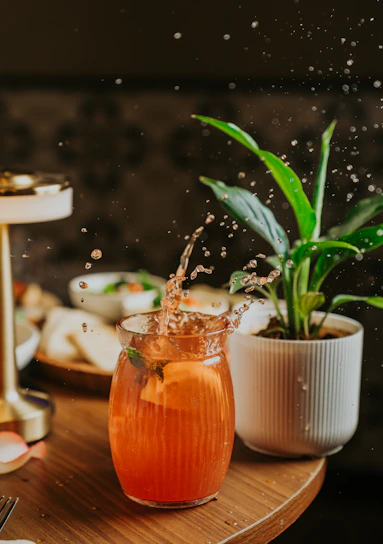 A drink is splashing out of a glass.