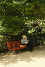 A man sits alone on a park bench.