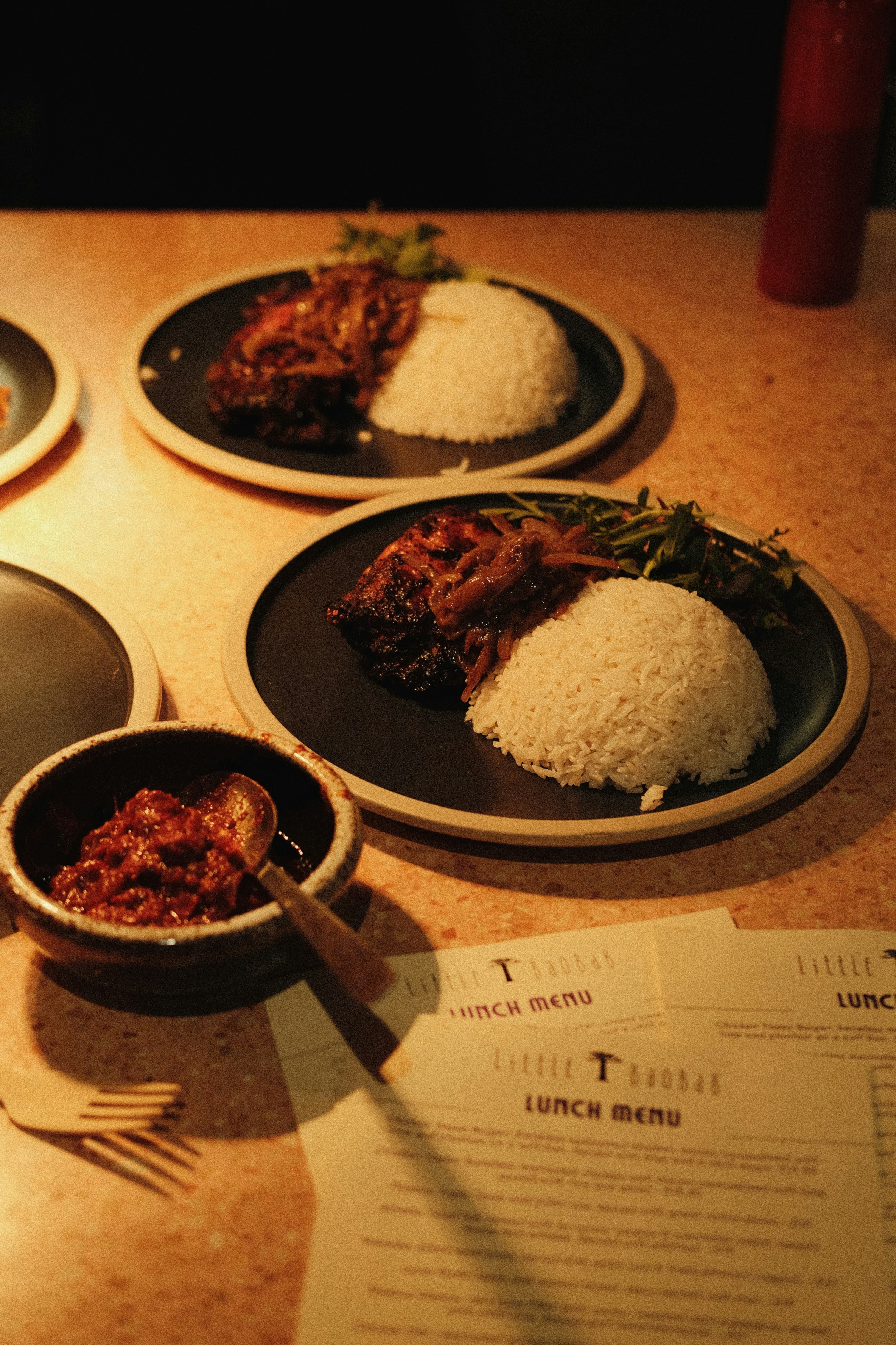 Plates of food with rice are served on a table.
