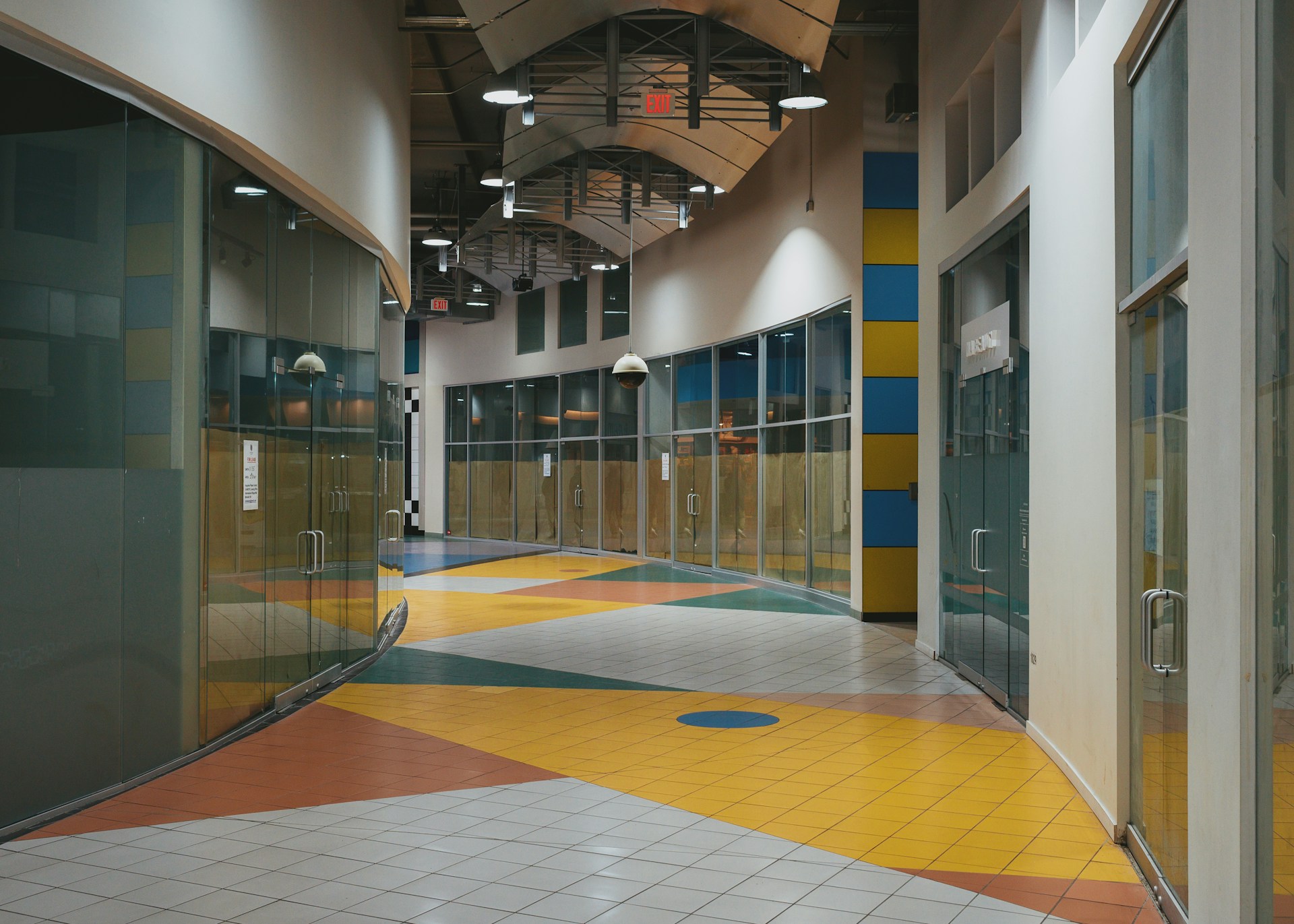 An empty hallway with glass storefronts.
