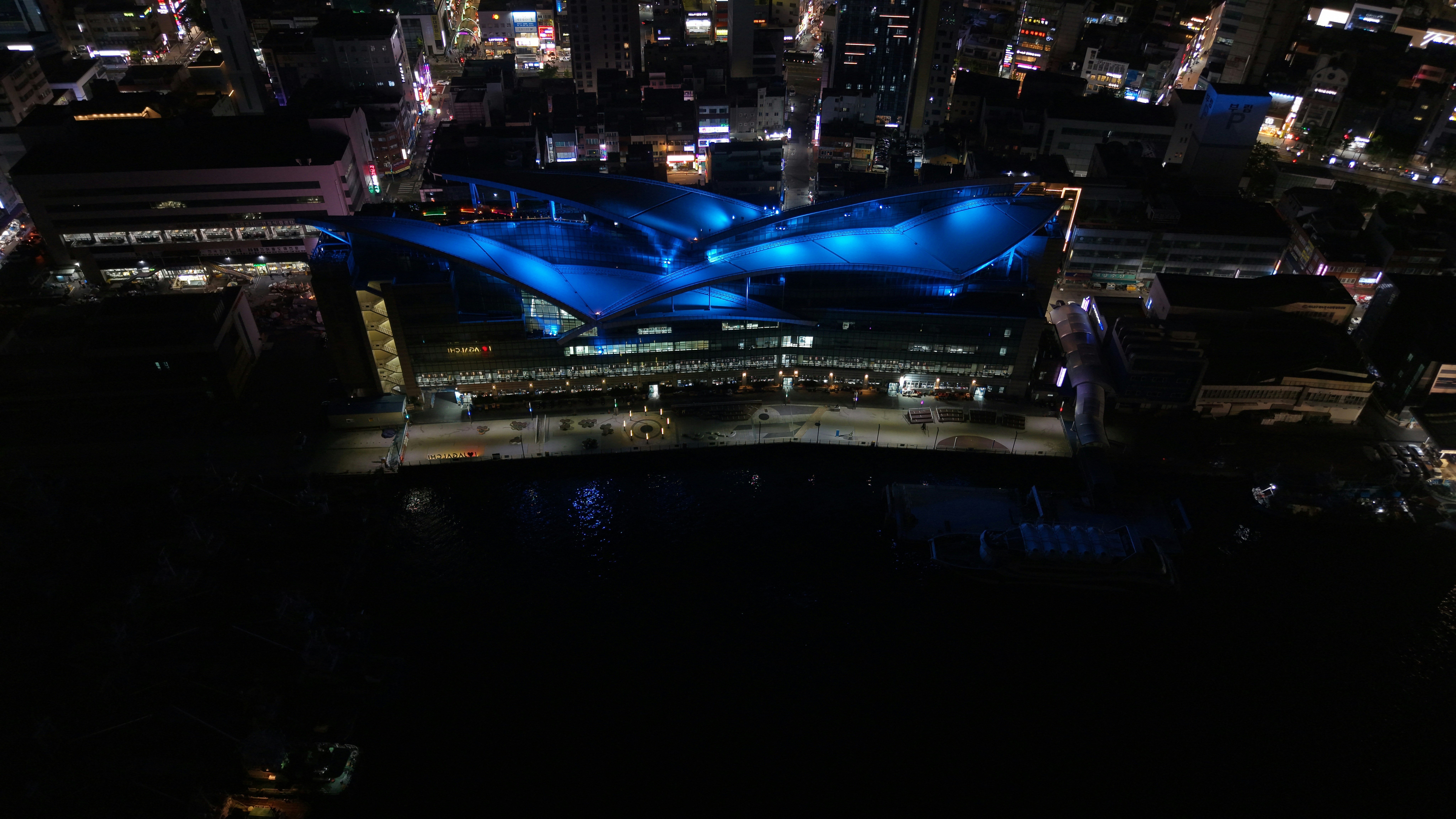 Nighttime aerial view of a modern illuminated building