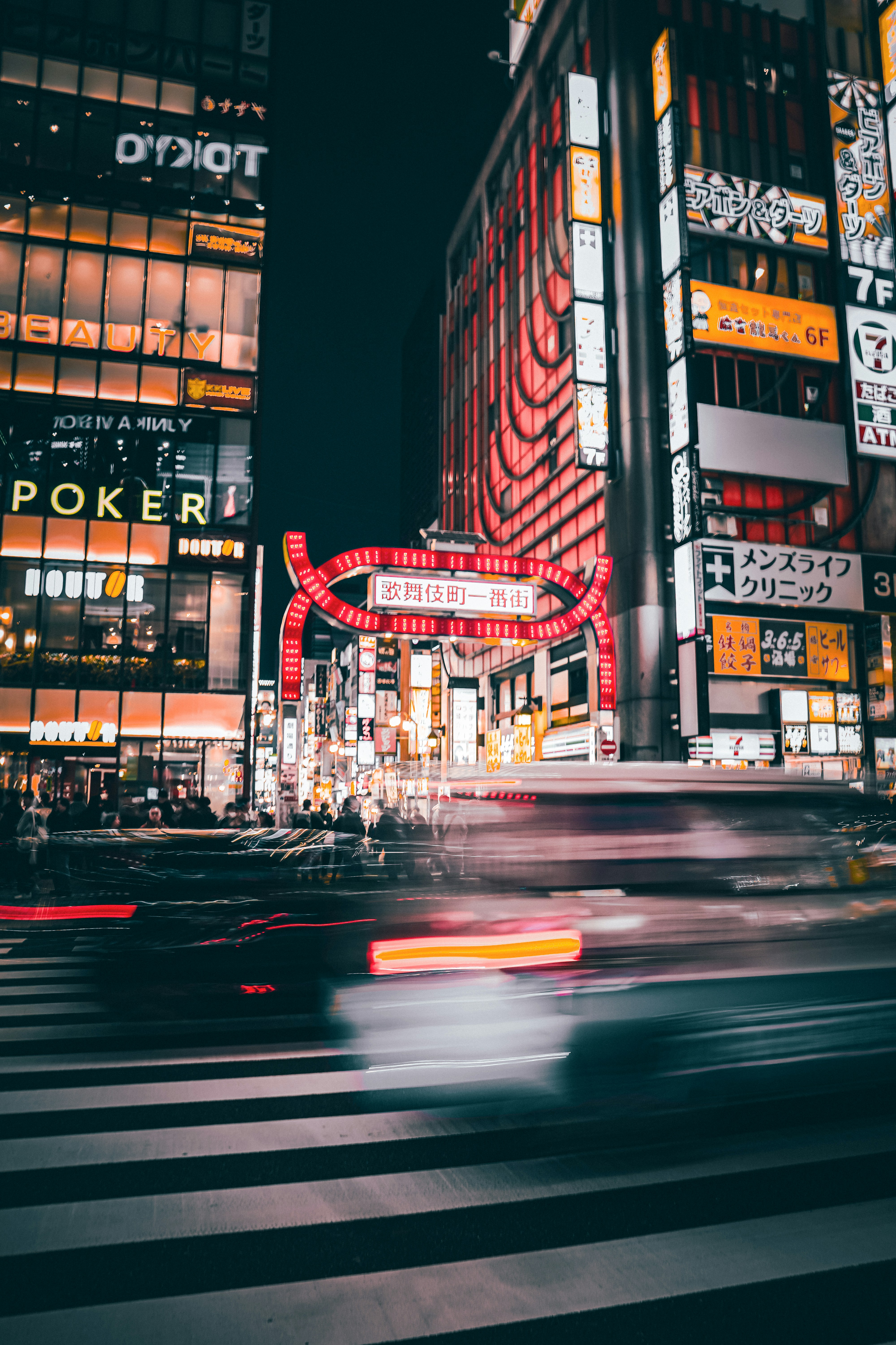 Illuminated buildings and moving cars in a city at night.