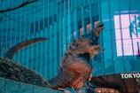 Godzilla statue in front of a building in tokyo.