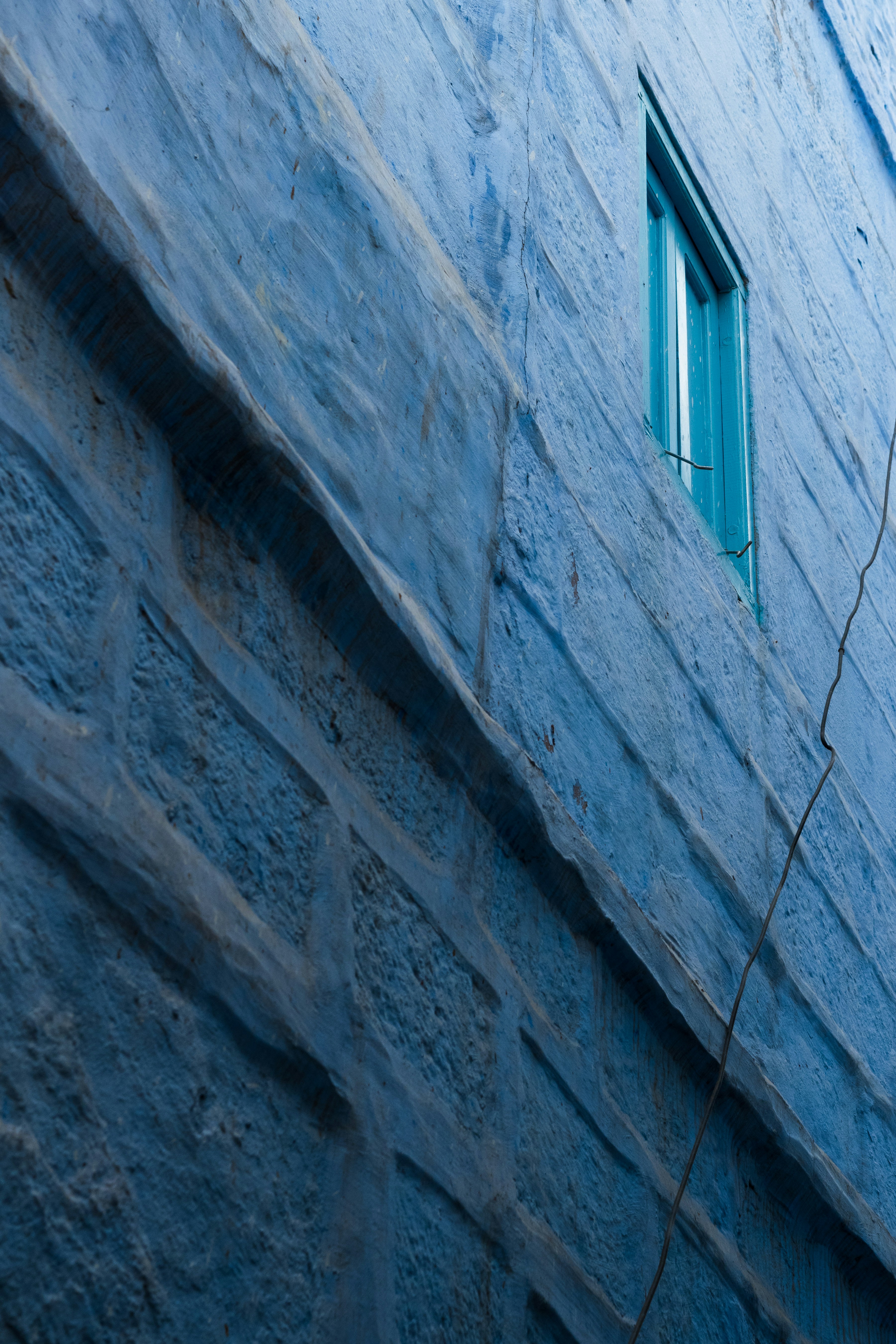 Blue wall with a teal window.