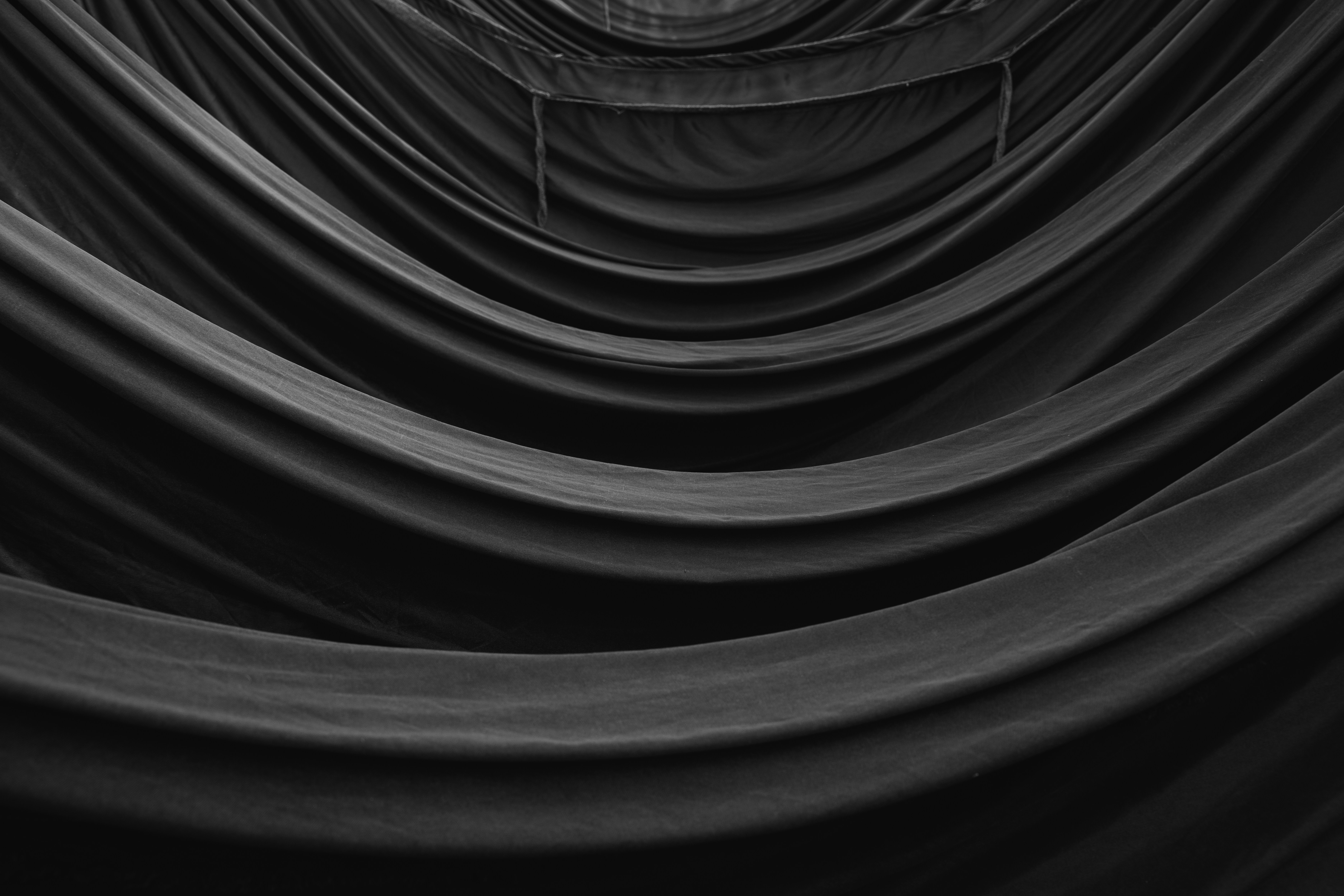 Dark, flowing fabric creates a wavy, abstract tunnel.