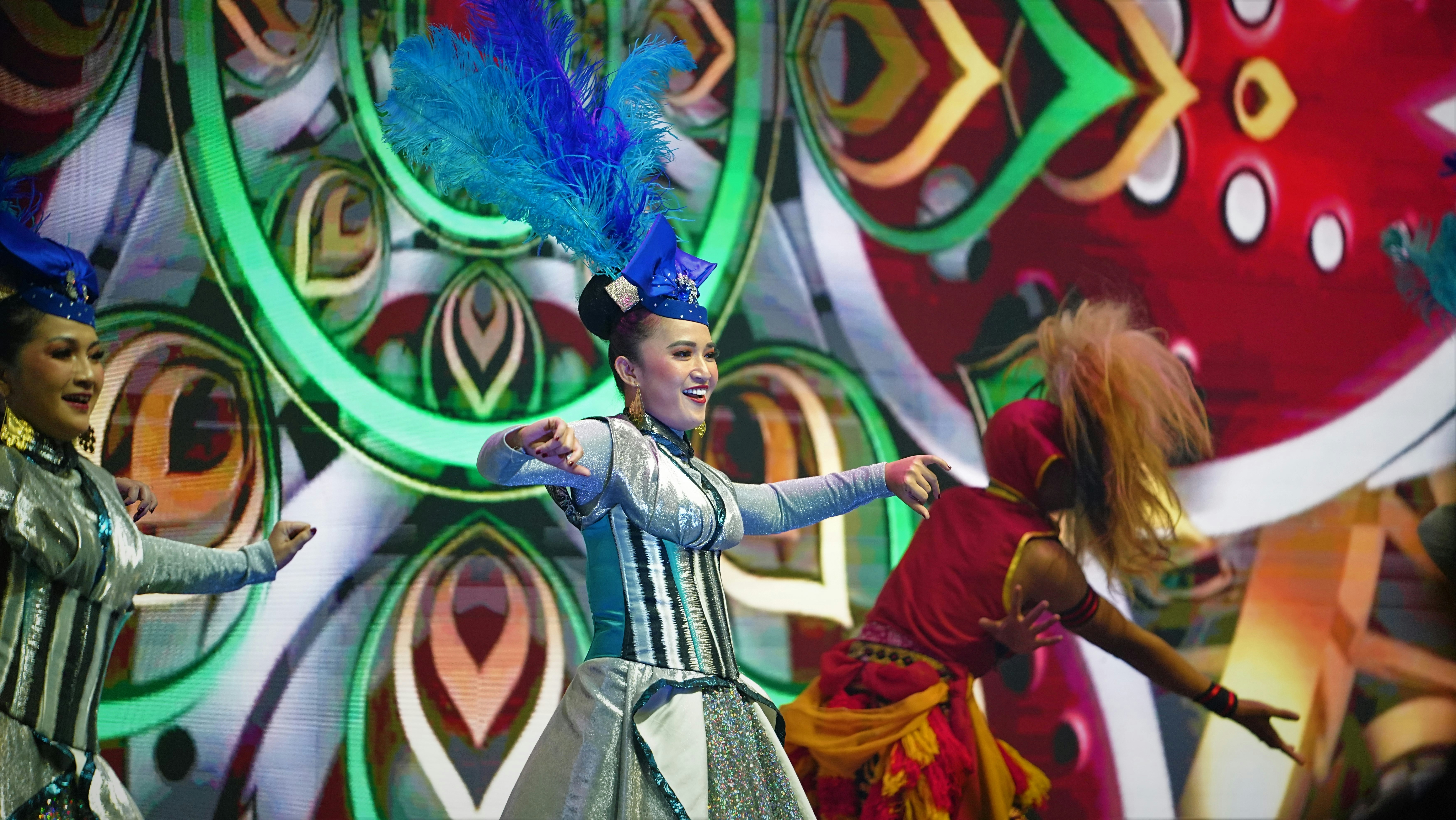 Dancers perform on stage with bright costumes.