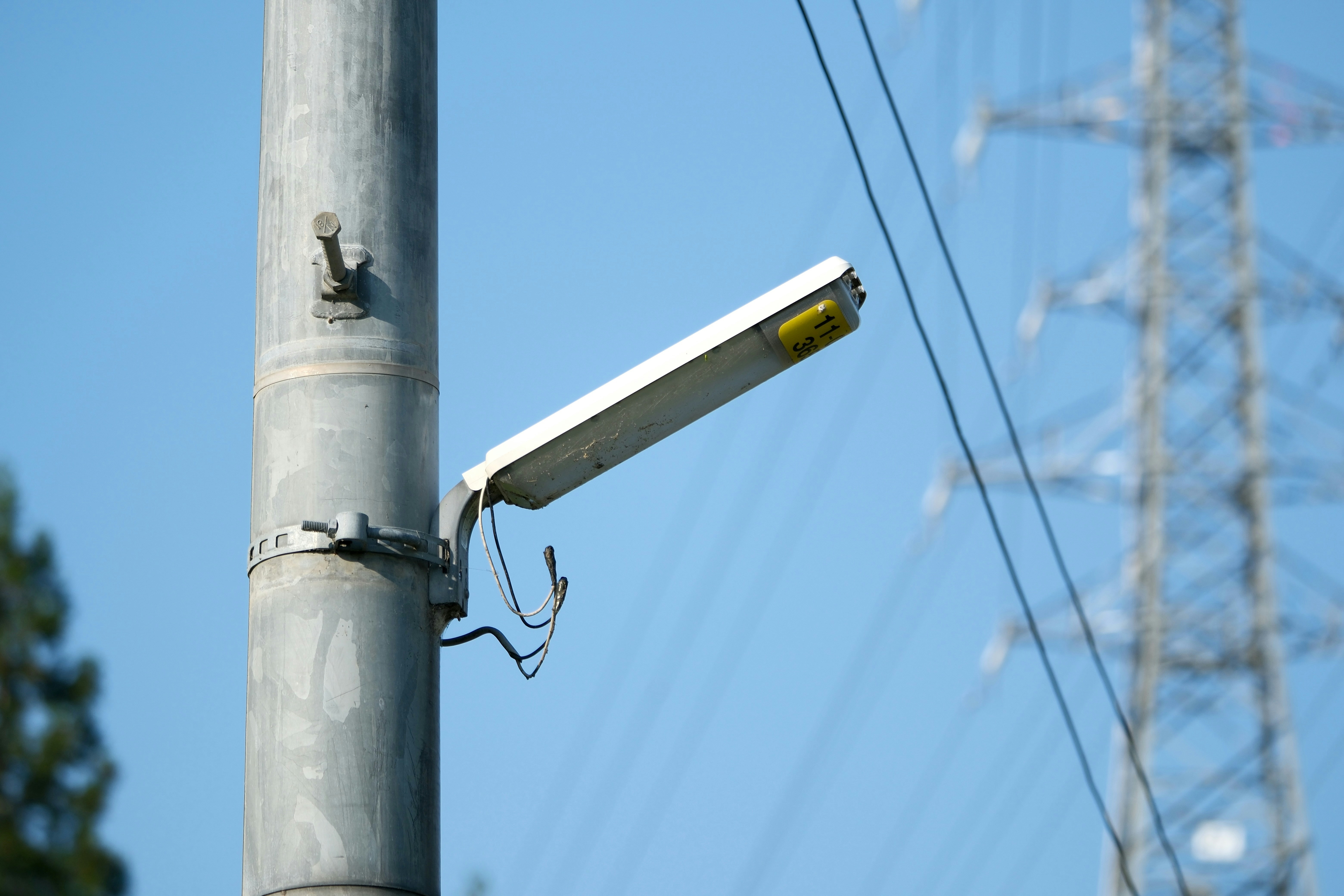 Street lamp next to an electricity pylon.