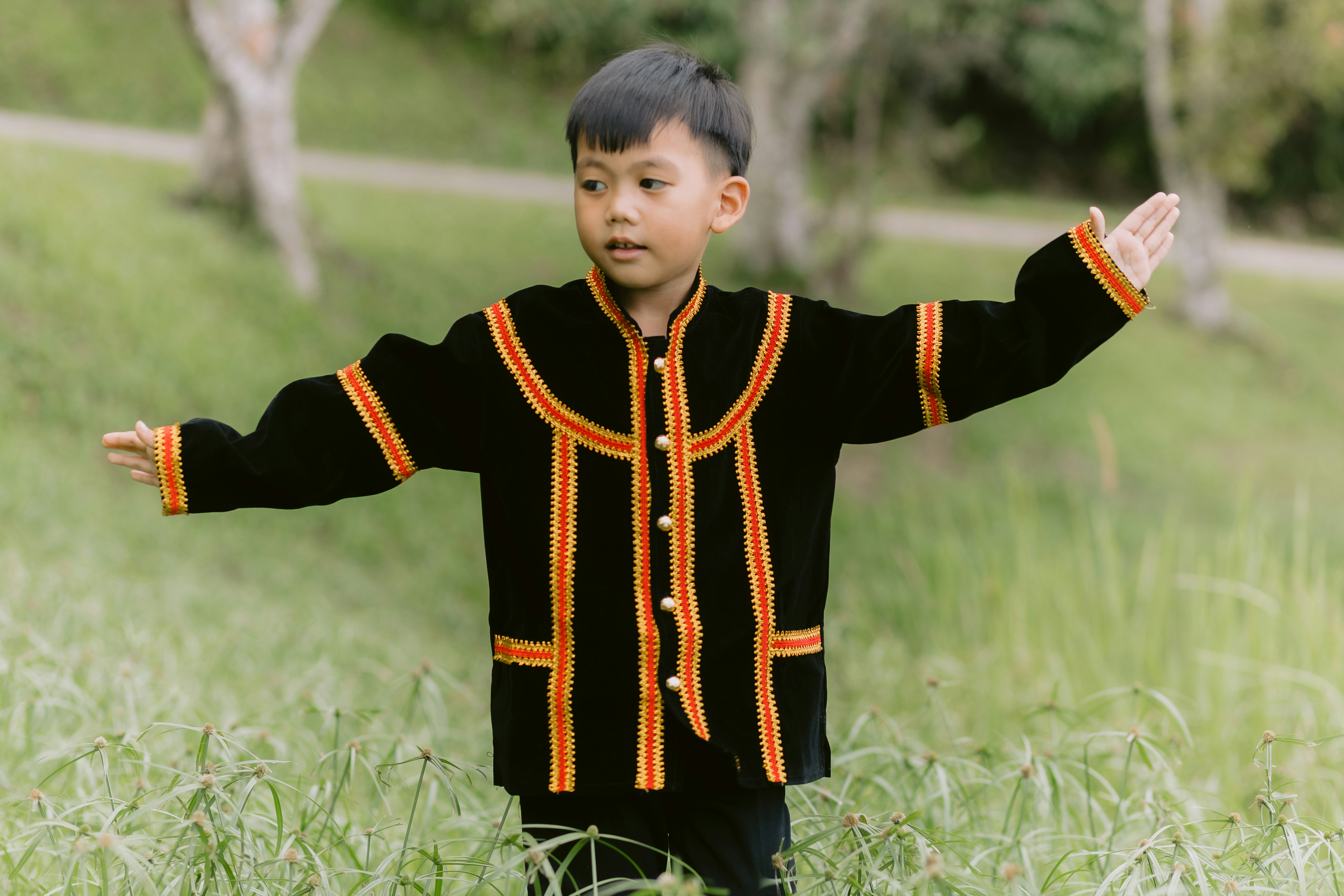 Boy posing in traditional clothing outdoors