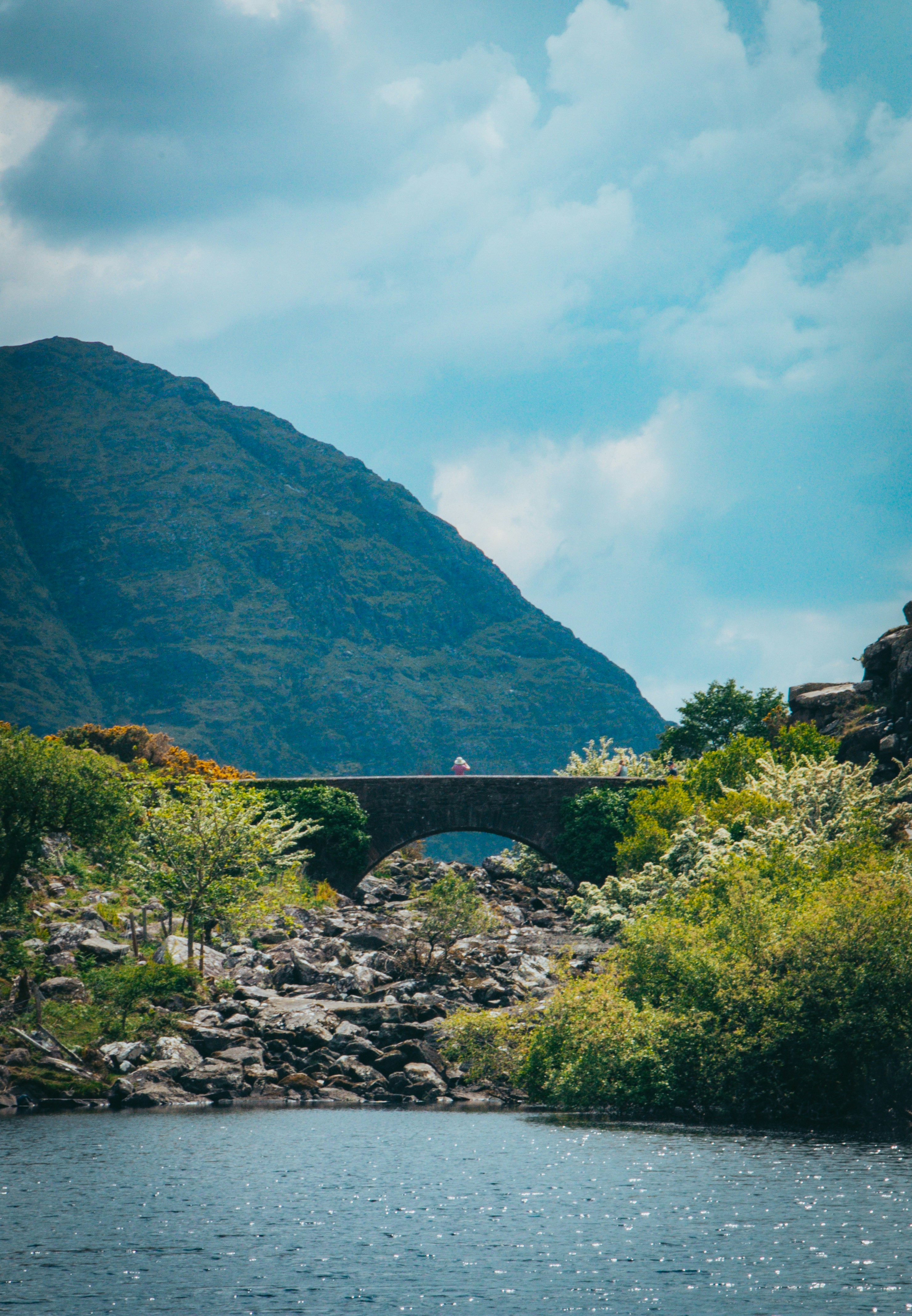 Bridge and a mountain overlook a body of water.