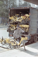 A worker unloads yellow bikes from a truck.