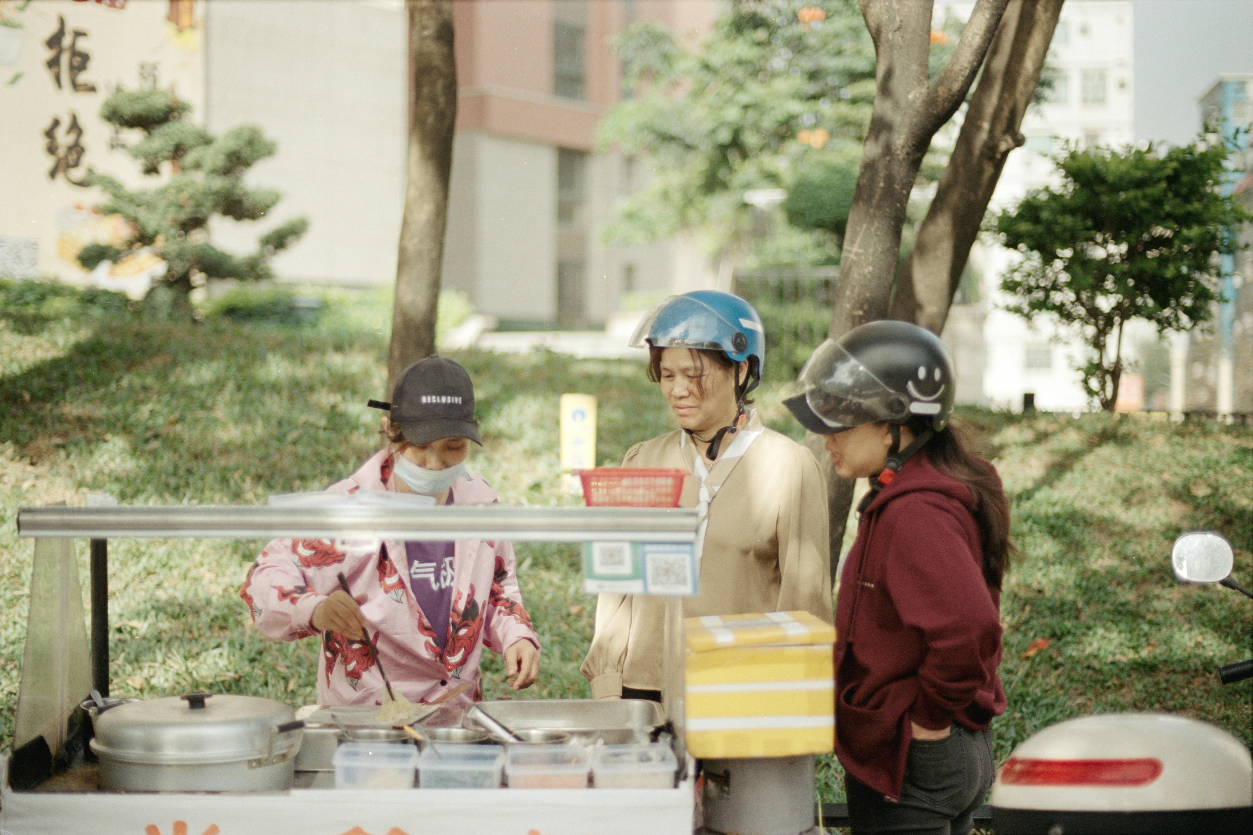People are buying food at a street vendor