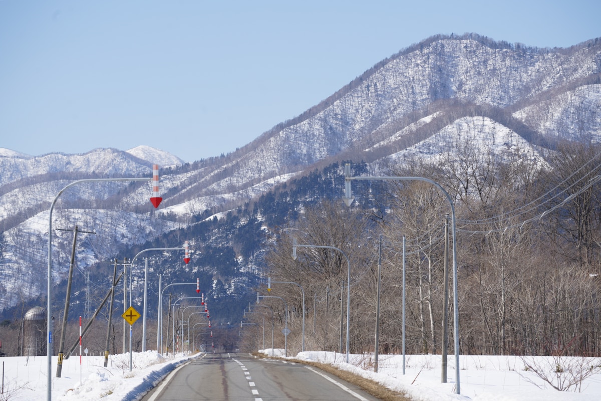 日本冬季積雪道路通往遠方雪山的雪地路況