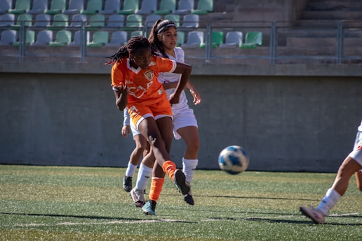 A soccer player kicks the ball during a game.