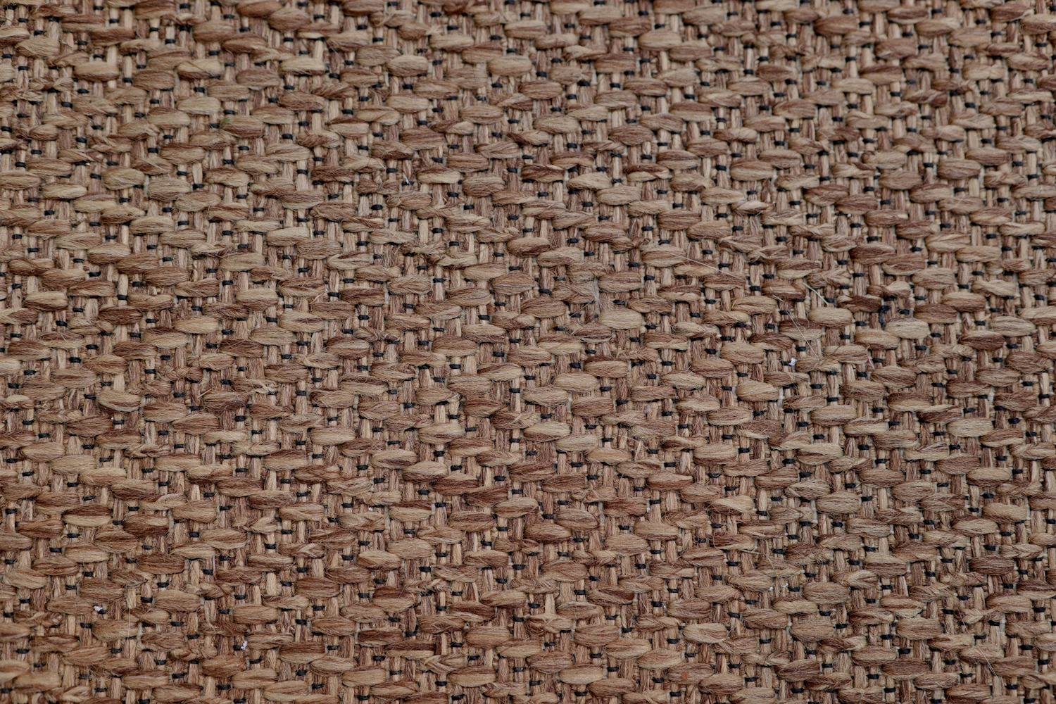 Close weave of brown coating cloth filling the frame, the twill line running corner to corner