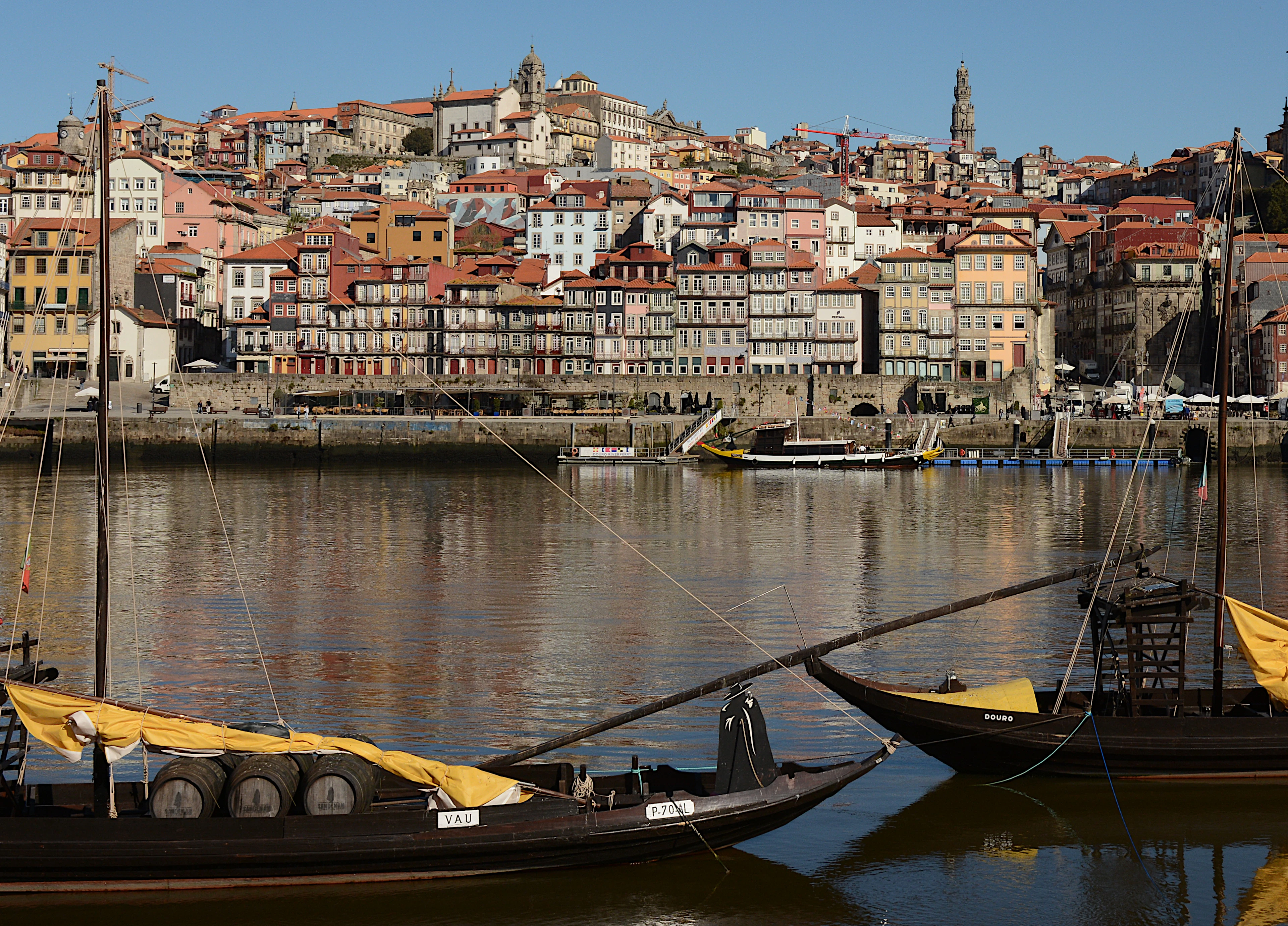 Traditional rabelo boats moored on the Douro before Porto's colorful hillside old town.