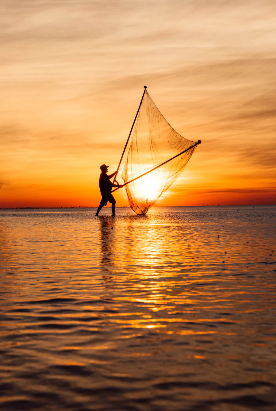 Pescador lançando rede ao entardecer