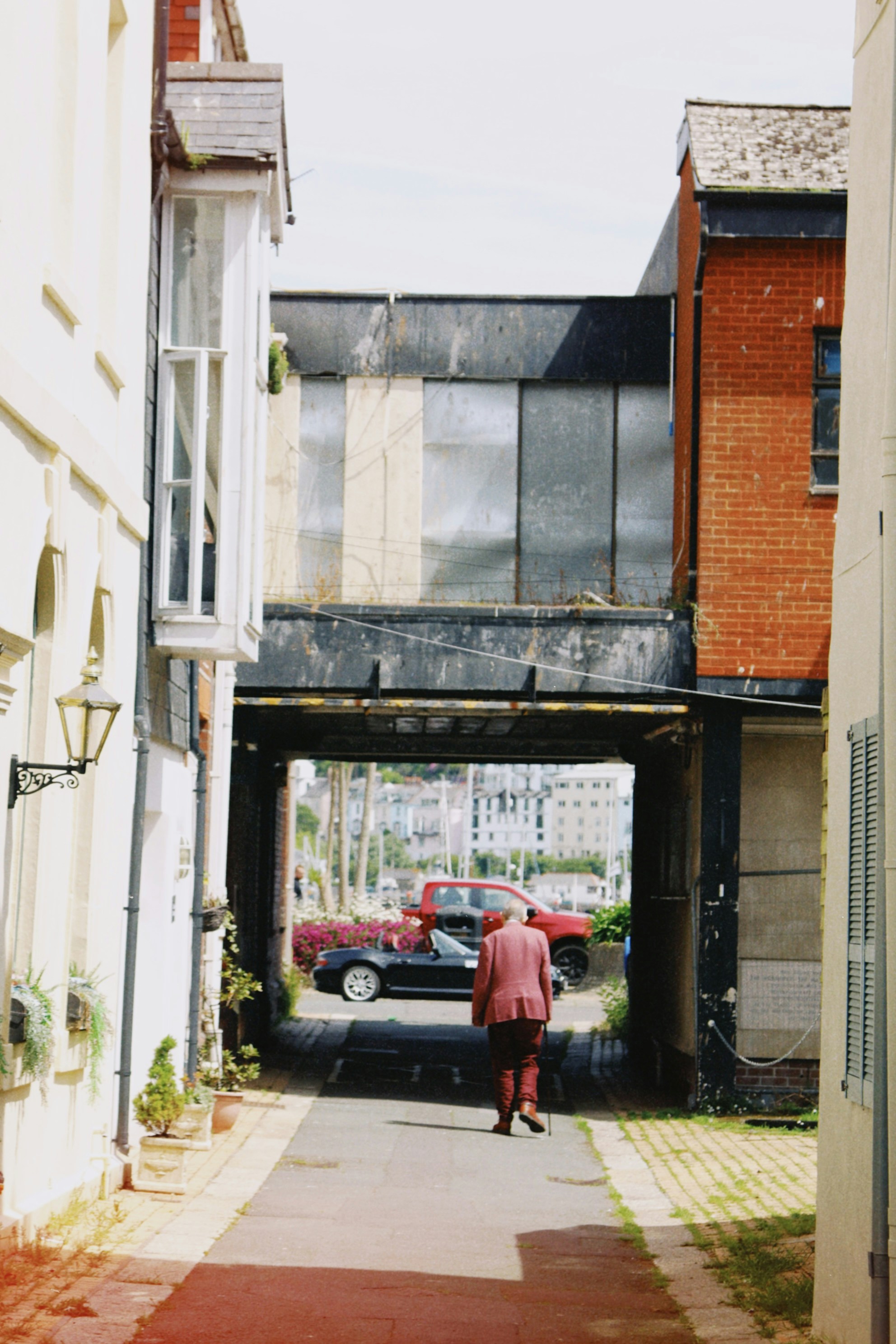 A man walks through an arched pathway. photo – Free Car Image on Unsplash