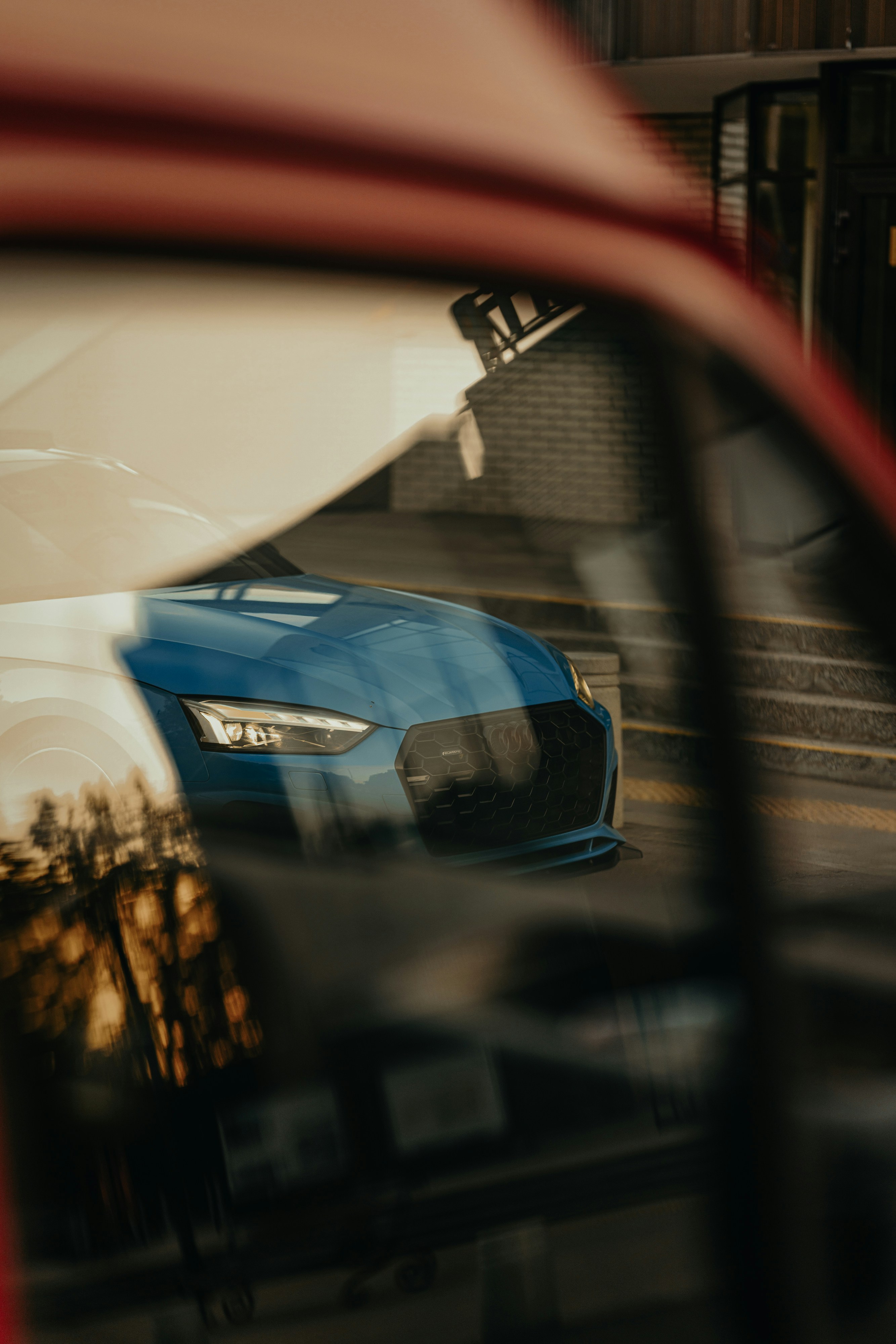 A blue car is reflected in a window.