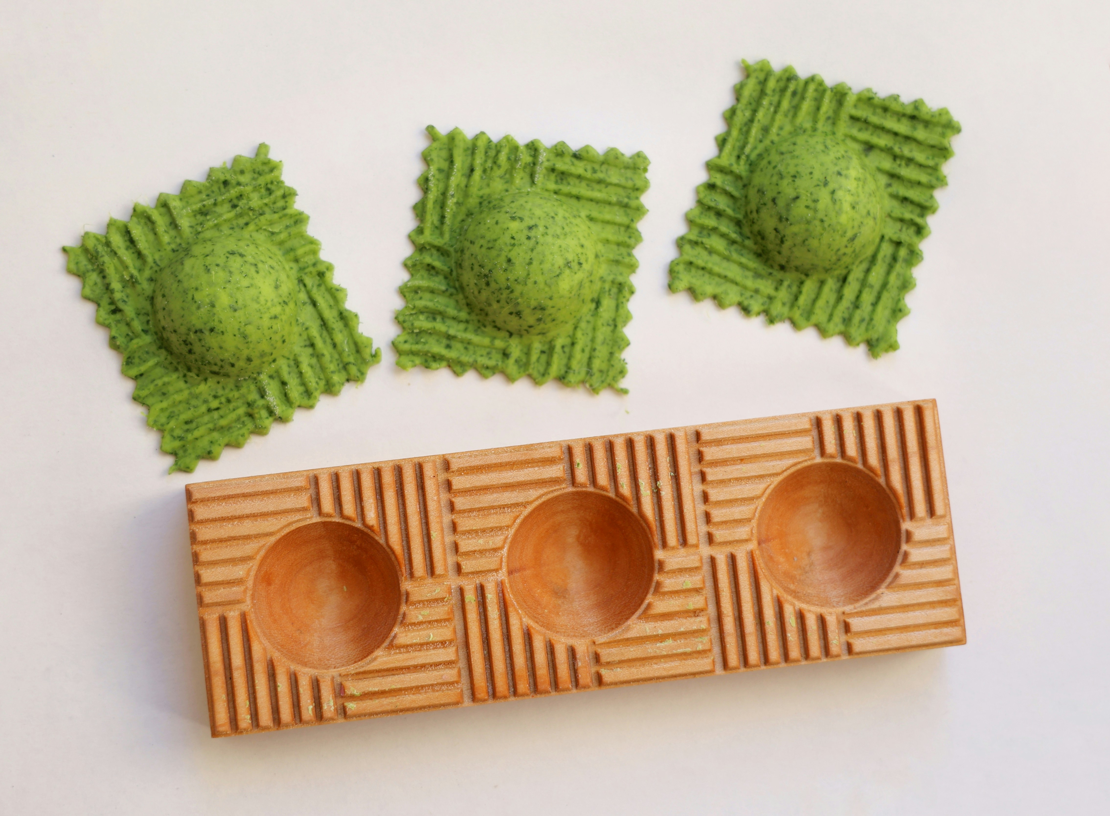 Three felted spheres and a wooden holder.