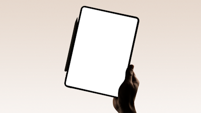 A hand holds a tablet with a blank screen.